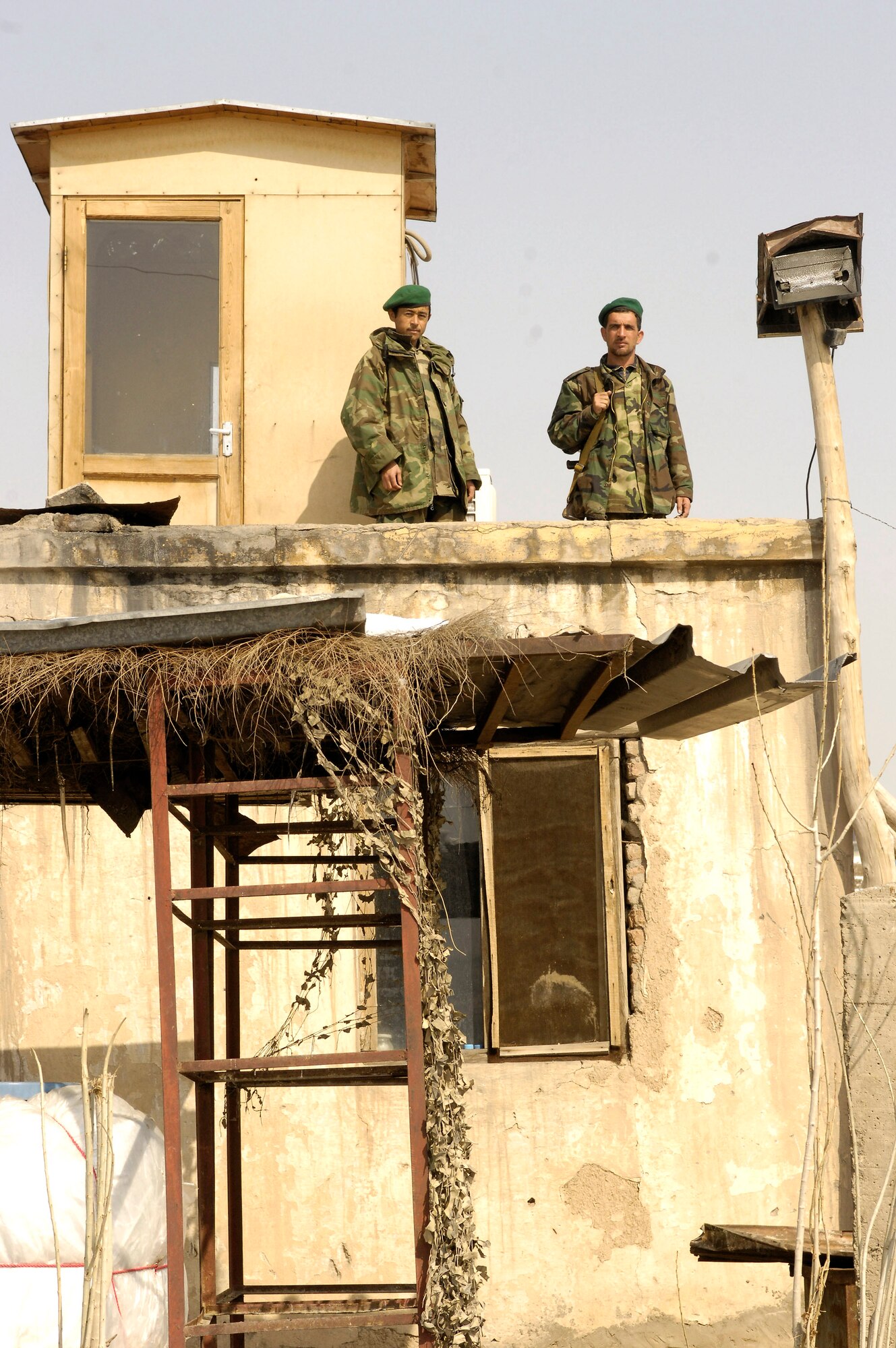 Afghanistan national army soldiers stand atop a security tower Feb. 17 at Khair-Khana, Afghanistan. The soldiers live in the building below when not on duty. Airmen from the 755th Air Expeditionary Group, Logistics Embedded Training Team, Combined Security Transition Command-Afghanistan, assisted the ANA in transitioning from the outdated facility to a state-of-the-art class III fuel depot. (U.S. Air Force photo/Maj. Carie A. Parker) 