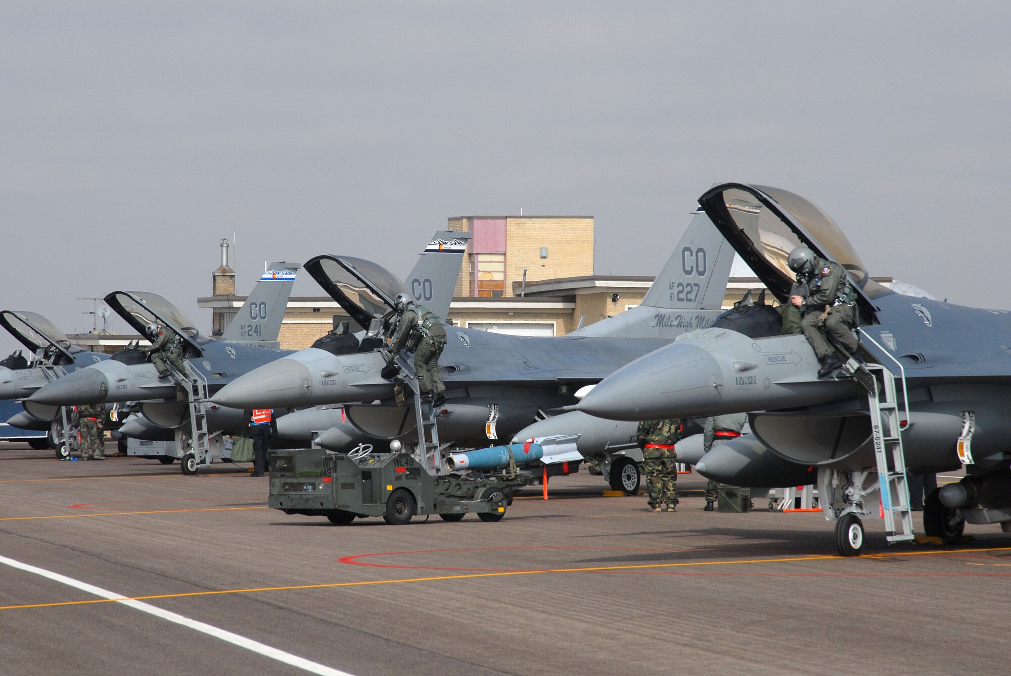 At the simulated forward operating base, pilots from the 120th Fighter Squadron egress from their F-16C aircraft as maintenance personnel prepare to regenerate the aircraft for the wartime scenario.  (Photo by SMSgt John Rohrer, 140th Wing Public Affairs)