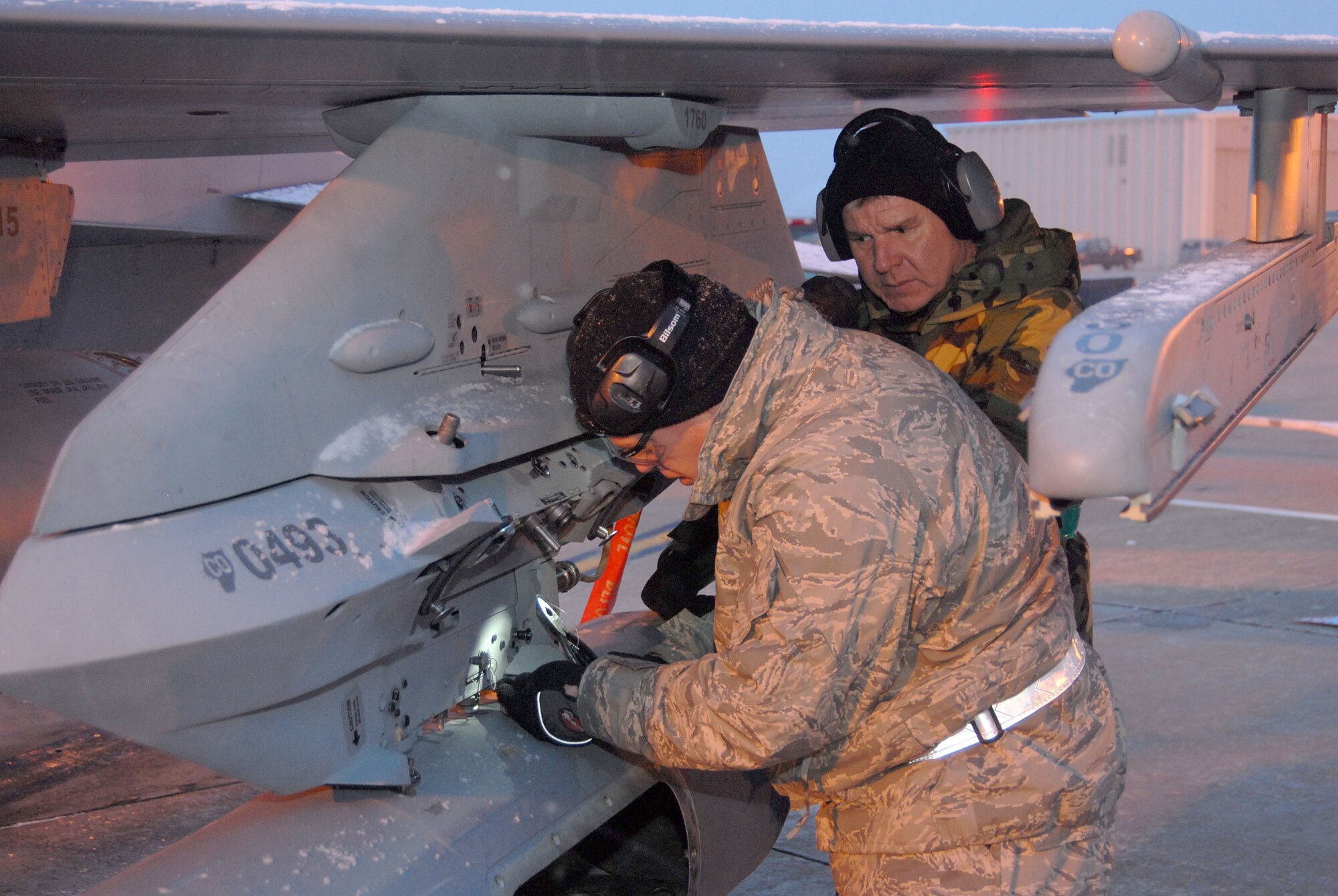 140th Wing Phase Dock personnel MSgt Dixon Eveleigh observs as TSgt Troy McDermott safety-wire a travel pod during an Operational Readiness Inspection.  (Photo by: SMSgt John Rohrer, 140th Wing Public Affairs)