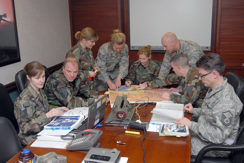 140th Wing Operation Support Squadron Intel Personnel Prepare for Briefs During an Operational Readiness Inspection.  They will be briefing the Commanders on the deployment orders as well as the pilots on the preferred routes for flight to their destination.  (Photo by SMSgt John Rohrer, 140th Wing Public Affairs)