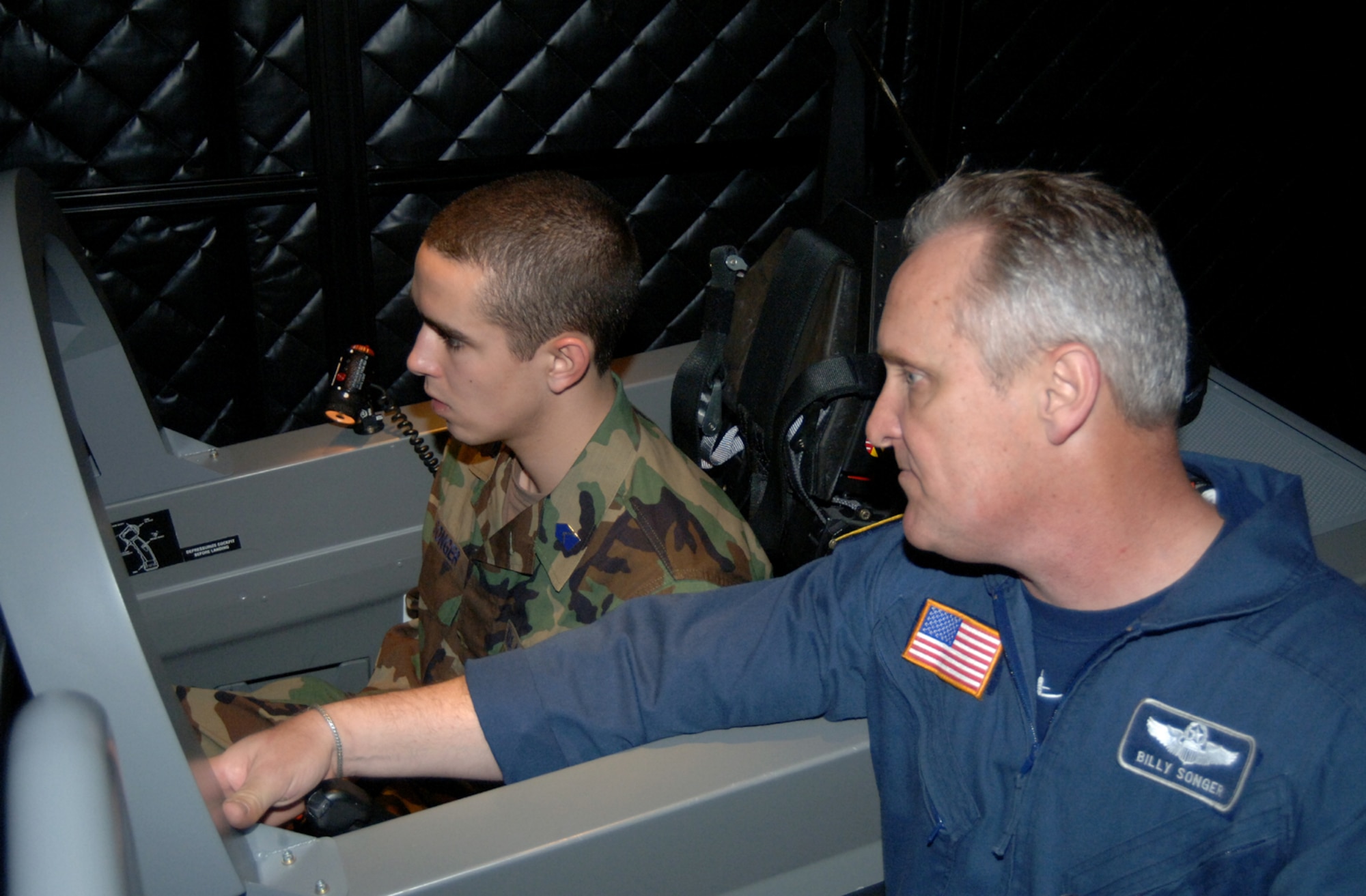 Billy Songer, an instructor with Lear Siegler Services, explains the T-6 Texan II simulator to his son, Cadet Brad Songer, a freshman in the Air Force Reserve Officer Training Corps program at Mississippi State University, during a MSU AF ROTC tour of Columbus Air Force Base Feb. 27. (U.S. Air Force photo/Senior Airman Jacob Corbin).