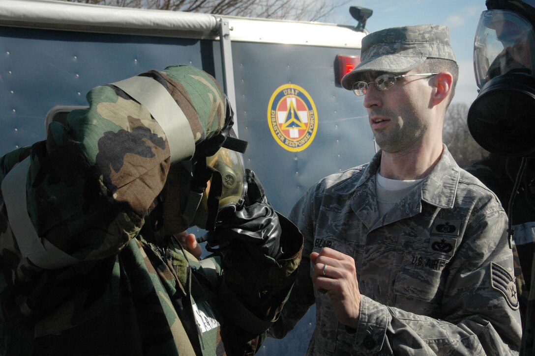 Sergeant Blair, right, observes as Tech. Sgt. Bob Weatherly, 89th Aerial Port Squadron NCO in charge of air terminal operations, demonstrates how to put on an MCU-2/protective mask for an airtight fit Feb. 19. (U.S. Air Force photo/ Bobby Jones)