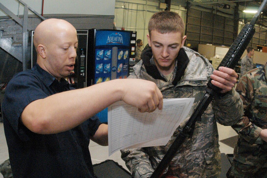 Montelle Johnson, Trendwestern mobilization warehouse supply technician, issues an M-4 rifle to Senior Airman Clancy Moulton, 89 APS air transportation specialist, at the mobility warehouse Feb. 27. (U.S. Air Force photo/ Bobby Jones)