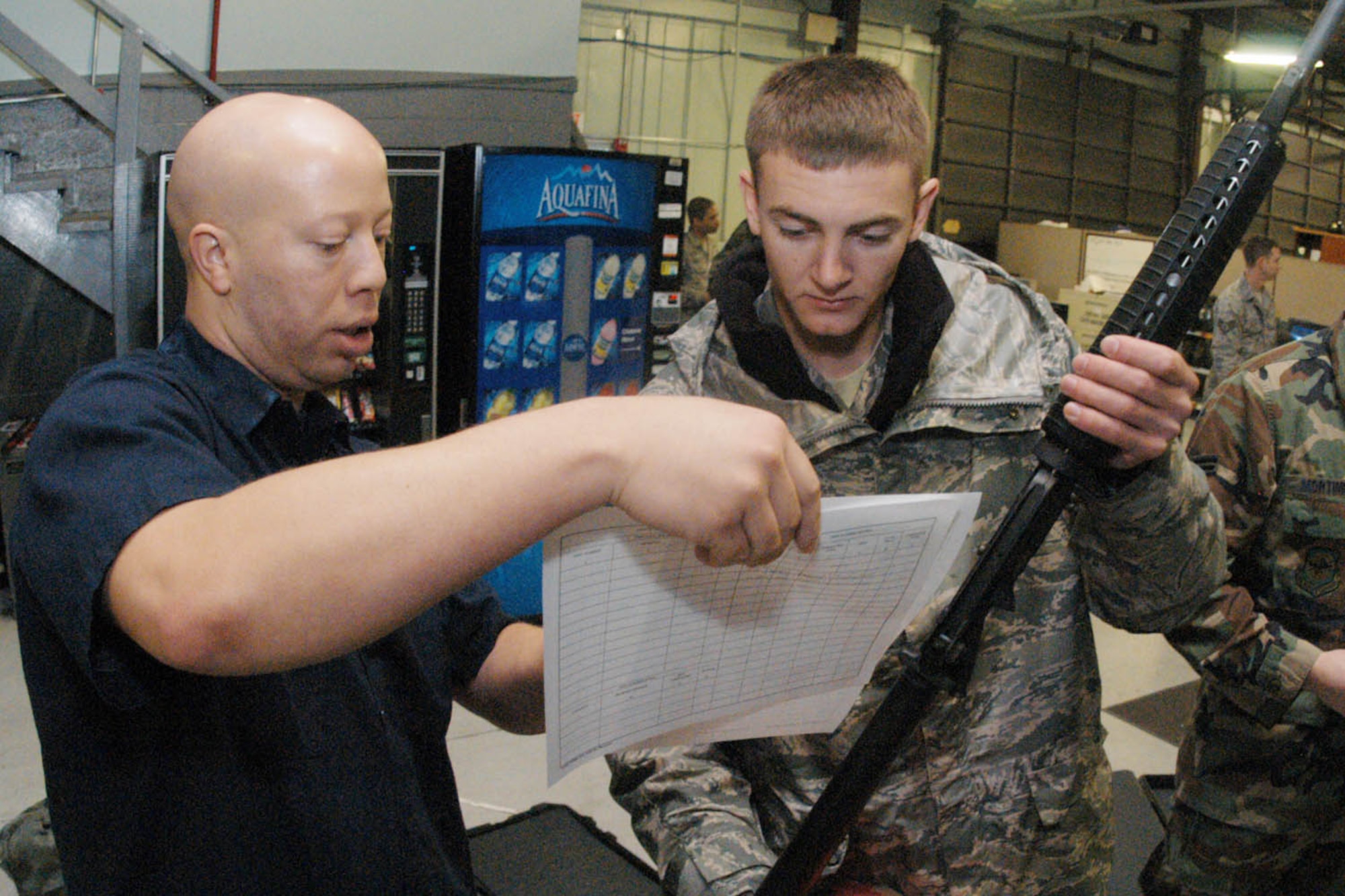 Montelle Johnson, Trendwestern mobilization warehouse supply technician, issues an M-4 rifle to Senior Airman Clancy Moulton, 89 APS air transportation specialist, at the mobility warehouse Feb. 27. (U.S. Air Force photo/ Bobby Jones)