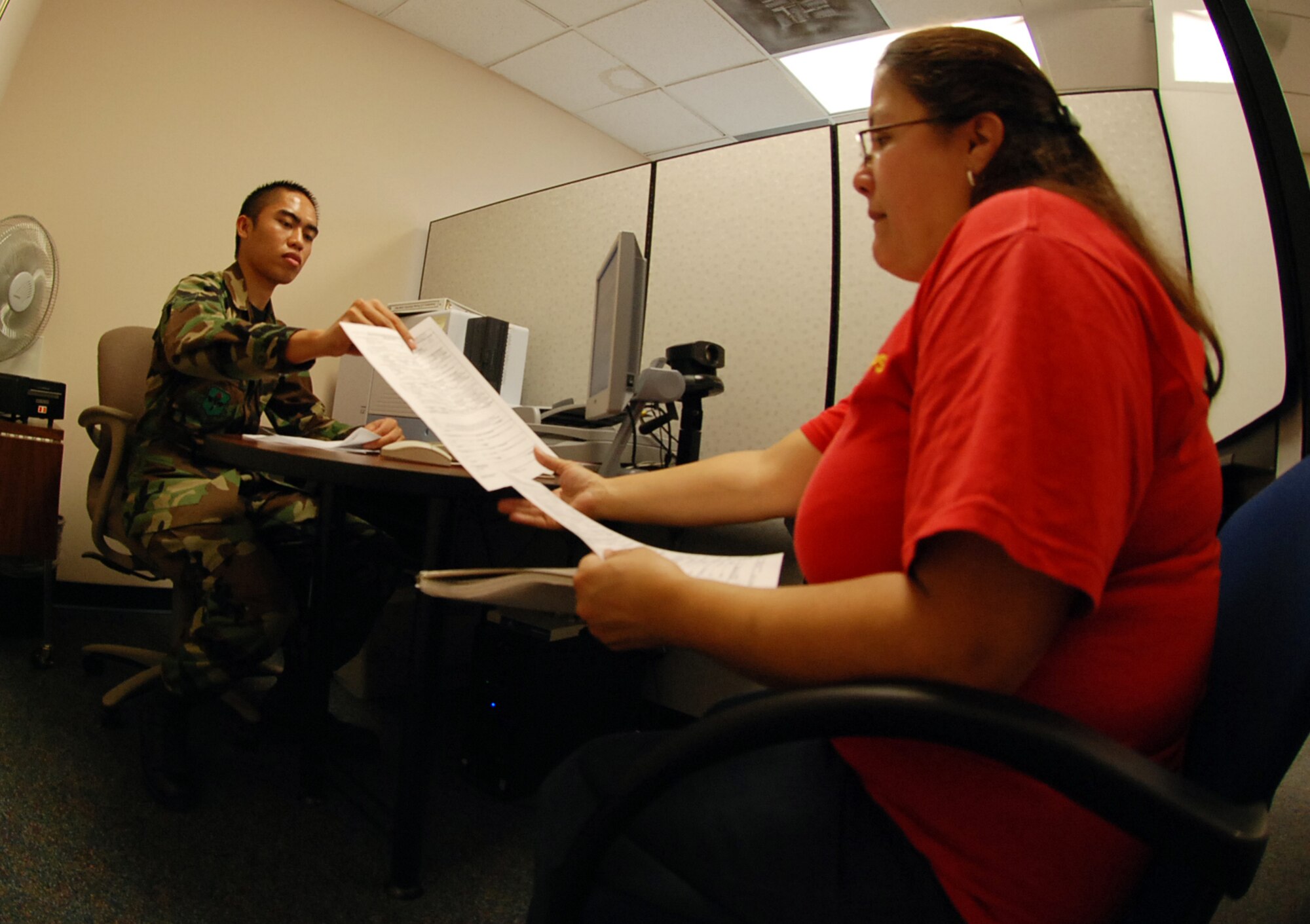 LAUGHLIN AIR FORCE BASE, Texas -- Lety Garcia, 47th Force Support Squadron, has paper work processed by Airman 1st Class Jim Umali, 47th FSS, customer service representative, at the newly renovated Military Personnel Flight here recently. (U.S. Air Force photo by Tech. Sgt. Charlie Miller)