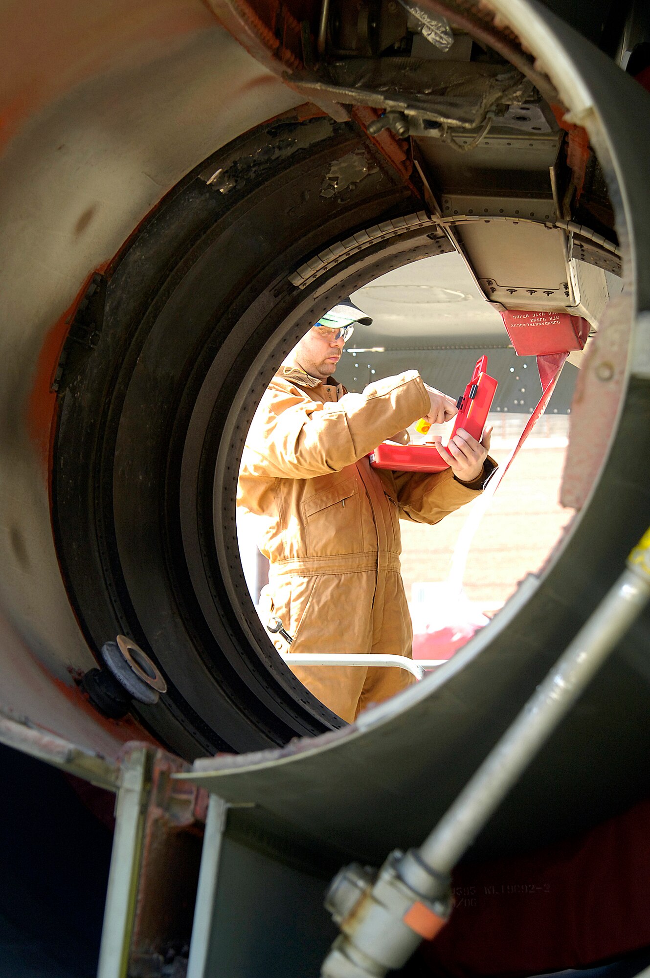 Robert Culpepper removes squibs, miniature explosive devices, from a KC-135’s No. 3 strut before the aircraft is moved into a hangar for depot work. The aircraft has 10 squibs that during an engine fire would instigate releasing fire retardant.(Air Force photo/Margo Wright)