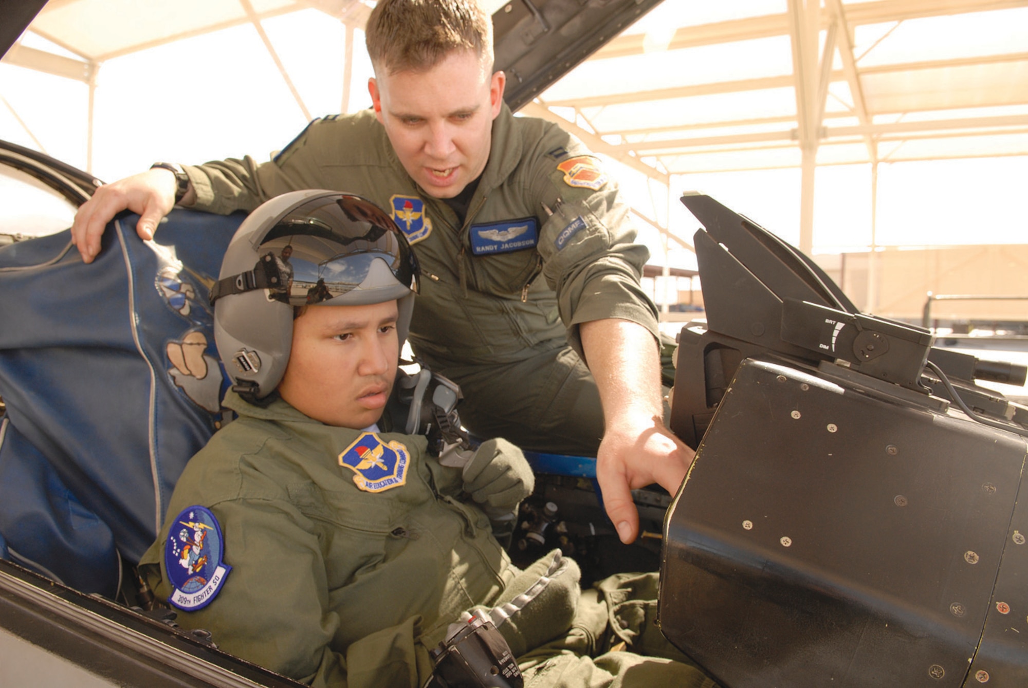 Capt. Randy Jacobson, 309th Fighter Squadron instructor pilot, shows Alex “Speed” Silva, 15, around the cockpit of an F-16 Fighting Falcon Feb 26. Alex took part in the Pilot for a Day program, which gives children who are ill opportunities to learn flight operations here at Luke. (U.S. Air Force photo/ Staff Sgt. Ian Dean)