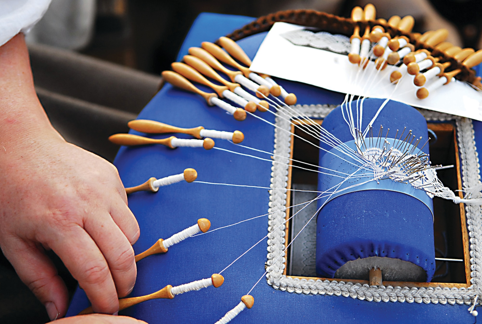 An exhibitor makes lace at Croft Thistlewood Village, an area of the Arizona Renaissance Festival where visitors learn how clothes and shoes were made in the 16th century. (U.S. Air Force photo/ C.J. Hatch.)