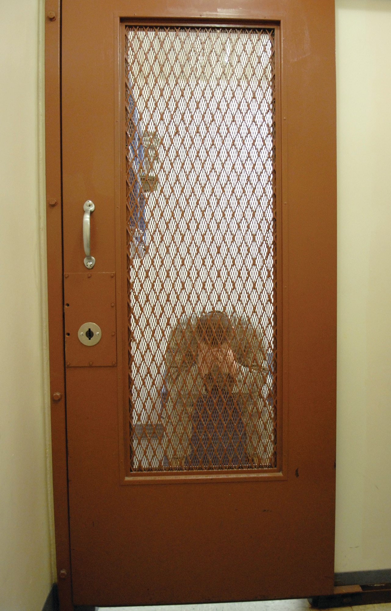 Photo illustration of an ‘inmate’ locked in one of the three cells at the confinement center. (photo/Debbie Silliman-Wolfe)