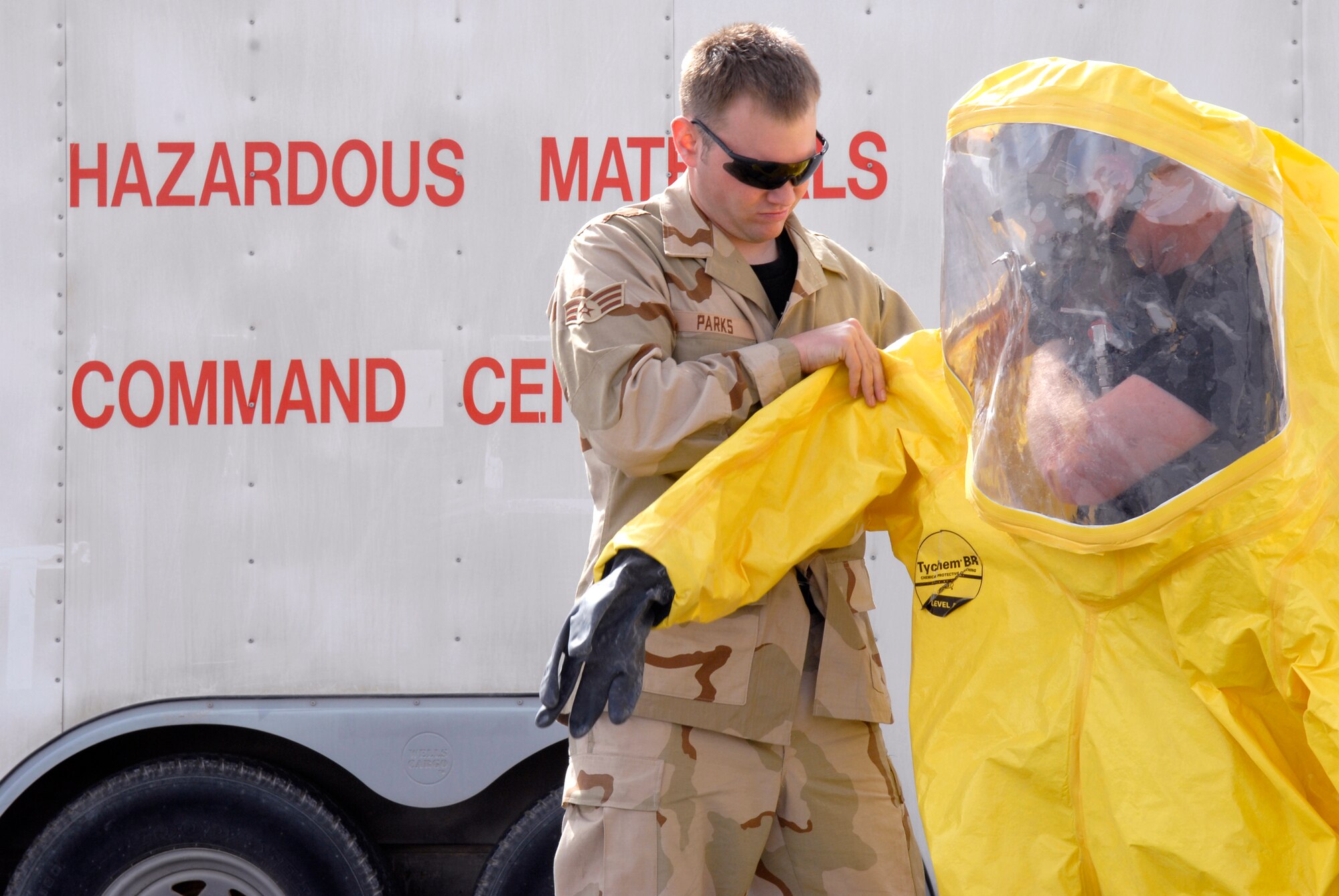 Senior Airman Kevin Parks and Senior Airman Mathew Babbitt, 379th Expeditionary Civil Engineer Squadron (ECES) Fire Fighters, work to put on a Hazardous Material suit for an exercise Mar. 5, 2009, at an undisclosed location in Southwest Asia.  The ECES fire fighters practice different drills on a monthly basis to maintain skills and readiness.  Airman Parks hails from Brooklyn Park, Minn. and is deployed from F. E. Warren Air Force Base (AFB), Wy.  Airman Babbitt hails from Boonville, Mo. and is deployed from Moody AFB, Ga.  Both are deployed in support of Operations Iraqi and Enduring Freedom and Combined Joint Task Force - Horn of Africa.  (U.S. Air Force Photo by Senior Airman Andrew Satran/Released)