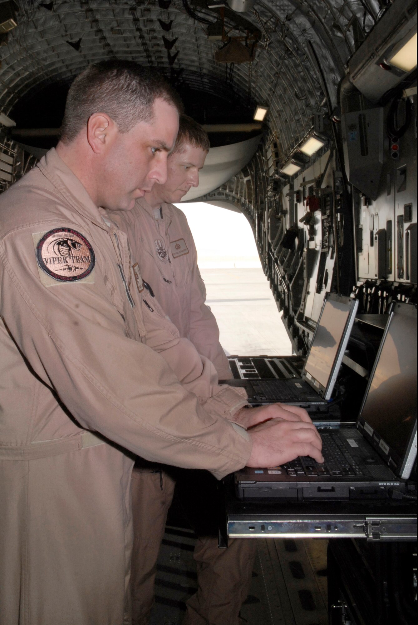 Technical Sergeant Bryan Doyea, 379th Expeditionary Communications Squadron (ECS) Viper Team Specialist NCO in charge, and Technical Sergeant Paul Bethancourt, 379th ECS Viper Team Specialist, set up their communications network in the cargo bay of a C-17 Globemaster III to provide extended communications capabilities during their mission Mar. 5, 2009, at an undisclosed base in Southwest Asia.  Tech. Sgt. Doyea hails from Dillworth, Minn. and is deployed from Grand Forks Air Force Base, N.D.  Tech. Sg. Bethancourt hails from New Orleans, La. and is deployed from Charleston Air Force Base, S.C. Both are deployed in support of Operations Iraqi and Enduring Freedom and Combined Joint Task Force - Horn of Africa.   (U.S. Air Force Photo by Senior Airman Andrew Satran/Released)