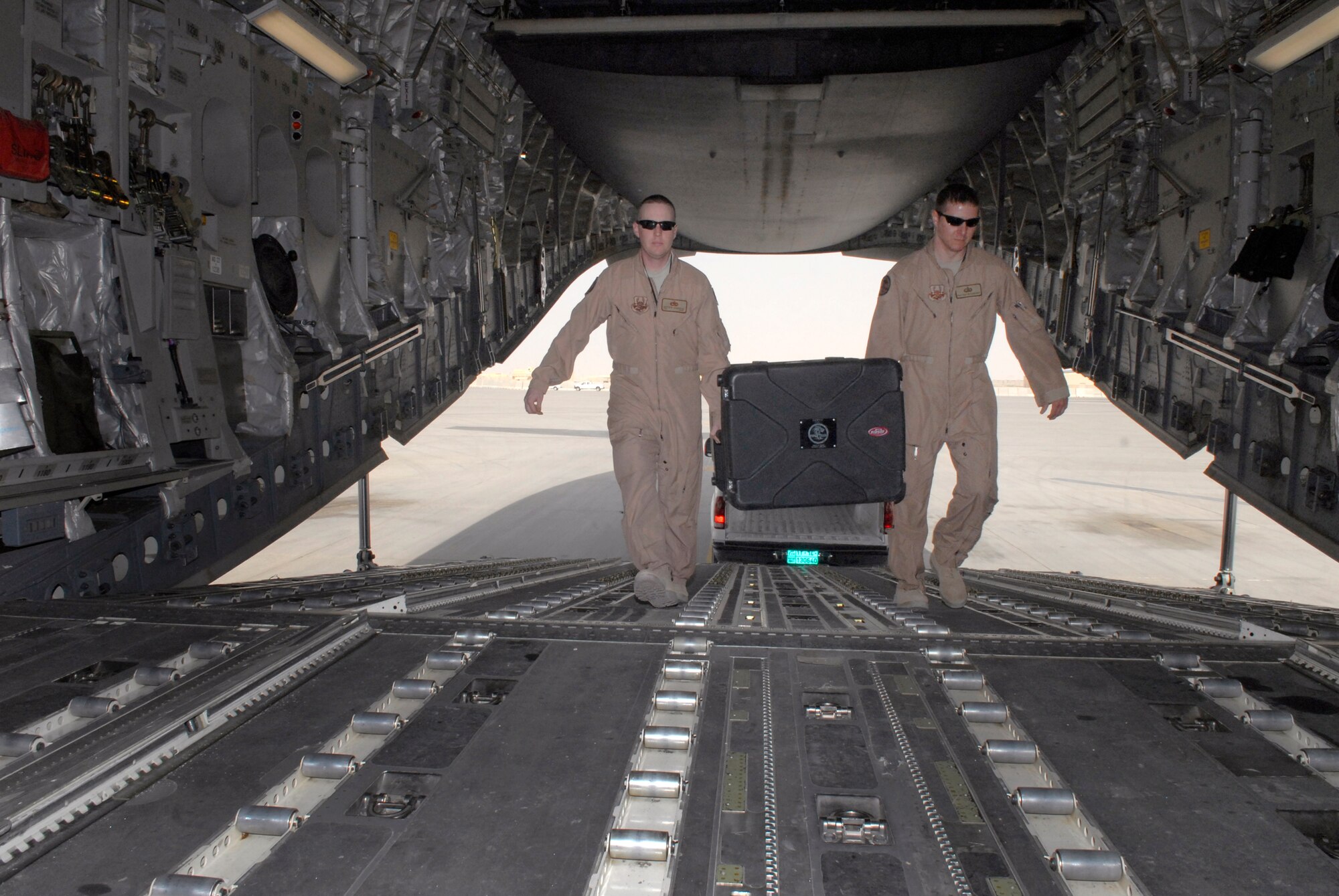 Staff Sergeant Matthew Henderson and Technical Sergeant Paul Bethancourt, 379th Expeditionary Communication Squadron Viper Team Specialists, bring their mobile communications equipment onto a C-17 Globemaster III to provide extended communications capabilities during their mission, Mar. 5, 2009 at an undisclosed location in Southwest Asia.  Staff Sgt. Henderson hails from Long Beach, Calif. and is deployed from Ramstein Air Base, Germany.  Tech. Sgt. Bethancourt hails from New Orleans, La. and is deployed from Charleston Air Force Base, S.C. Both are deployed in support of Operations Iraqi and Enduring Freedom and Combined Joint Task Force - Horn of Africa.  (U.S. Air Force Photo by Senior Airman Andrew Satran/Released)