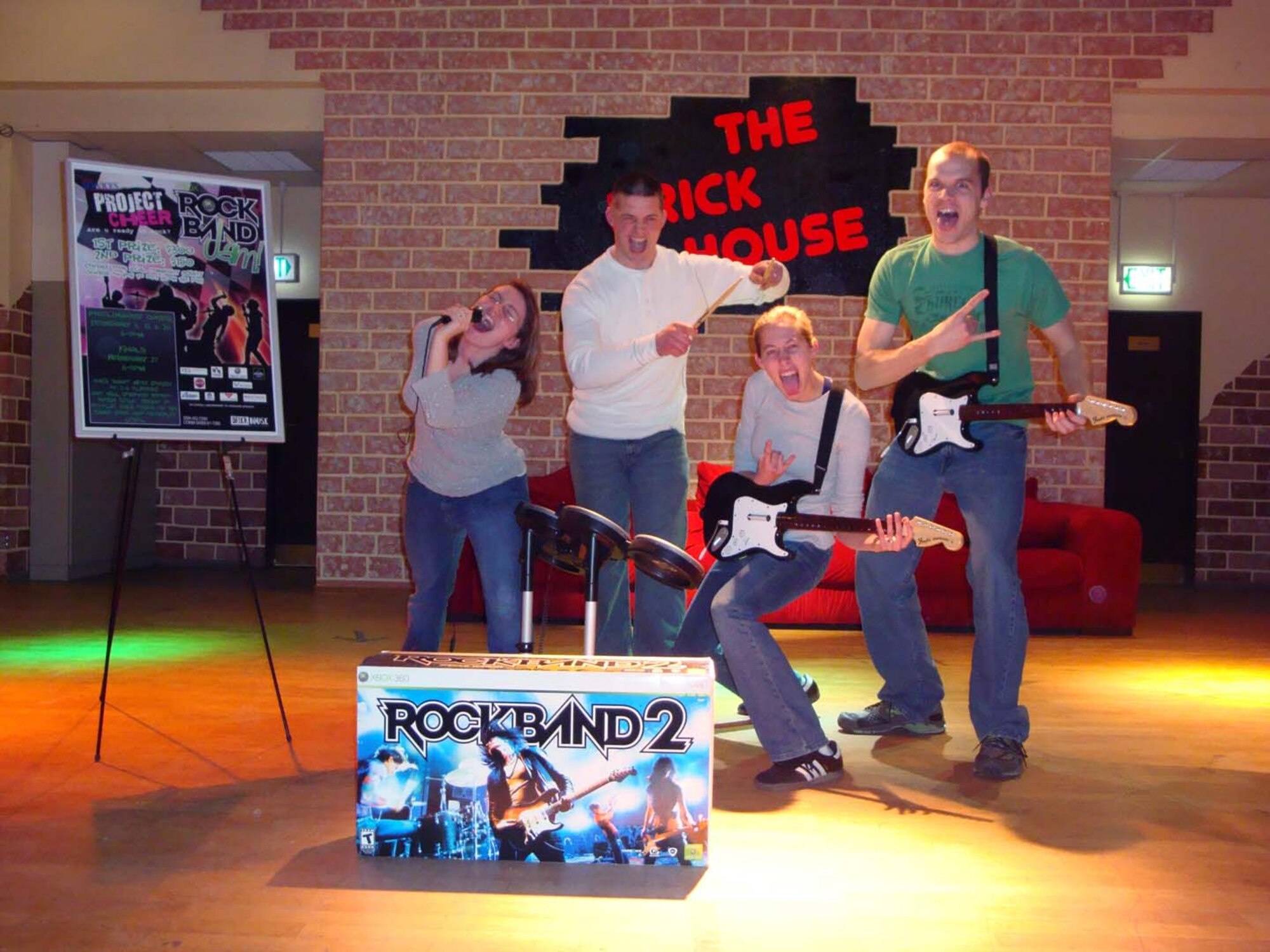 SPANGDAHLEM AIR BASE, Germany -- Members of Tainted Puppy enjoy their Project Cheer Rock Band Jam 2 victory on the Brick House stage Feb. 28, 2009. The band members are Senior Airman Nathan Crandall, 52nd Equipment Maintenance Squadron, and wife Jessica, both on guitar, Senior Airman Justin Lemmon, 52nd EMS, and wife Sarah. (U.S. Air Force photo by Andrew Rice)