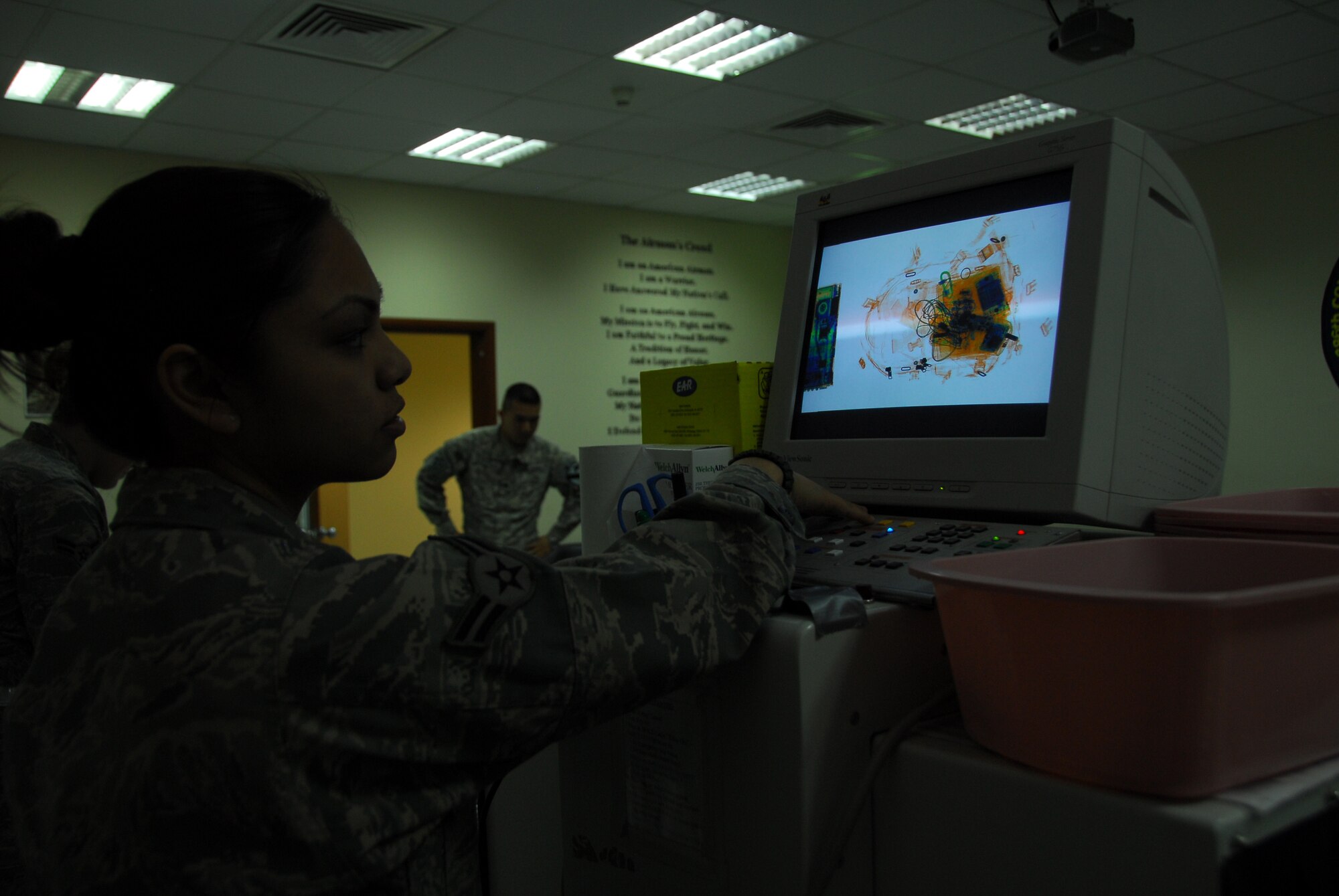 SOUTHWEST ASIA -- Airman 1st Class Alyssa Aguilar, 386th Expeditionary Medical Group, scans a book bag during the first phase of anti-hijacking security when patients first arrive at the medical facility at an air base in Southwest Asia, March 1. The bags are scanned to identify any weapons or ammunition. Airman Aguilar is deployed from Wright-Patterson AFB, OH, and is originally from Sacramento, Calif. (U.S. Air Force photo/ Senior Airman Courtney Richardson)