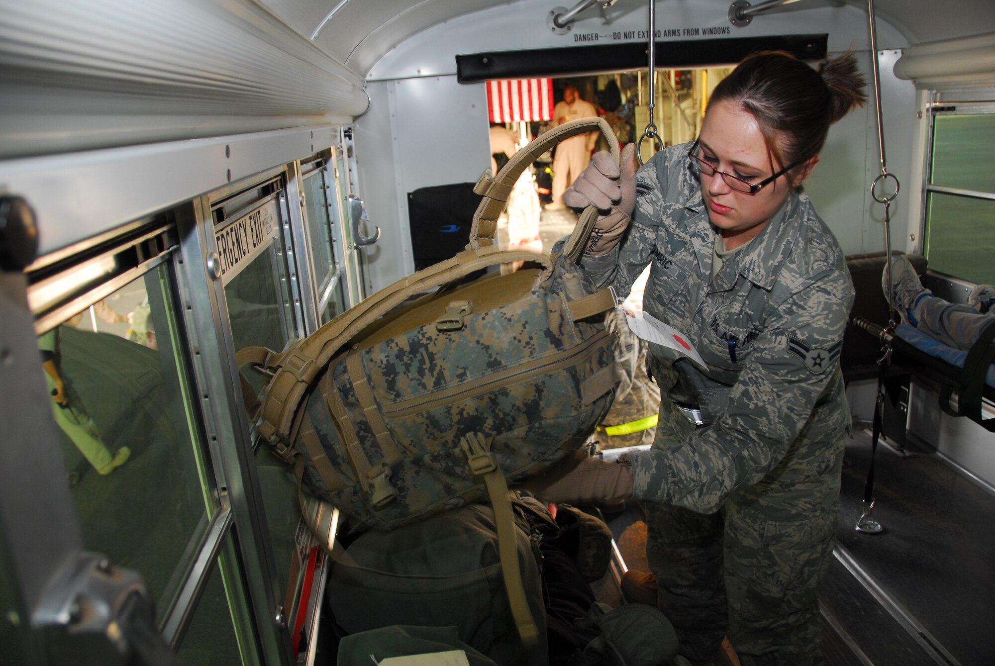 SOUTHWEST ASIA -- Airman 1st Class Cassandra Hamric, 386th Expeditionary Medical Group, loads the luggage of the wounded patients onto the Ambus at an air base in Southwest Asia, March 1. Once the bags are unloaded off of the aircraft, they are checked against a manifest to ensure all of the bags have arrived with the patients. Airman Hamric is deployed from Wright-Patterson AFB, OH and is originally from Canton, Mich. (U.S. Air Force photo/ Senior Airman Courtney Richardson)