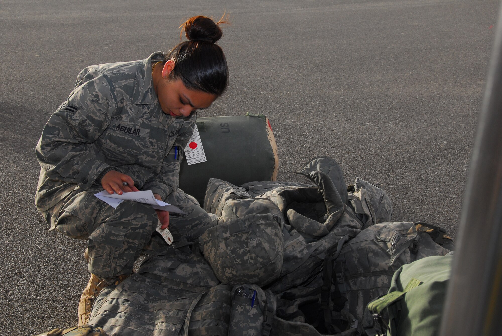 SOUTHWEST ASIA -- Airman 1st Class Alyssa Aguilar, 386th Expeditionary Medical Group, checks the baggage manifest for the Air Evacuation patients deplaning to the facility at an air base in Southwest Asia, March 1. All baggage is accounted for to ensure the patient arrive with all of their personal items. Airman Aguilar is deployed from Wright-Patterson AFB, OH, and is originally from Sacramento, Calif. (U.S. Air Force photo/ Senior Airman Courtney Richardson)