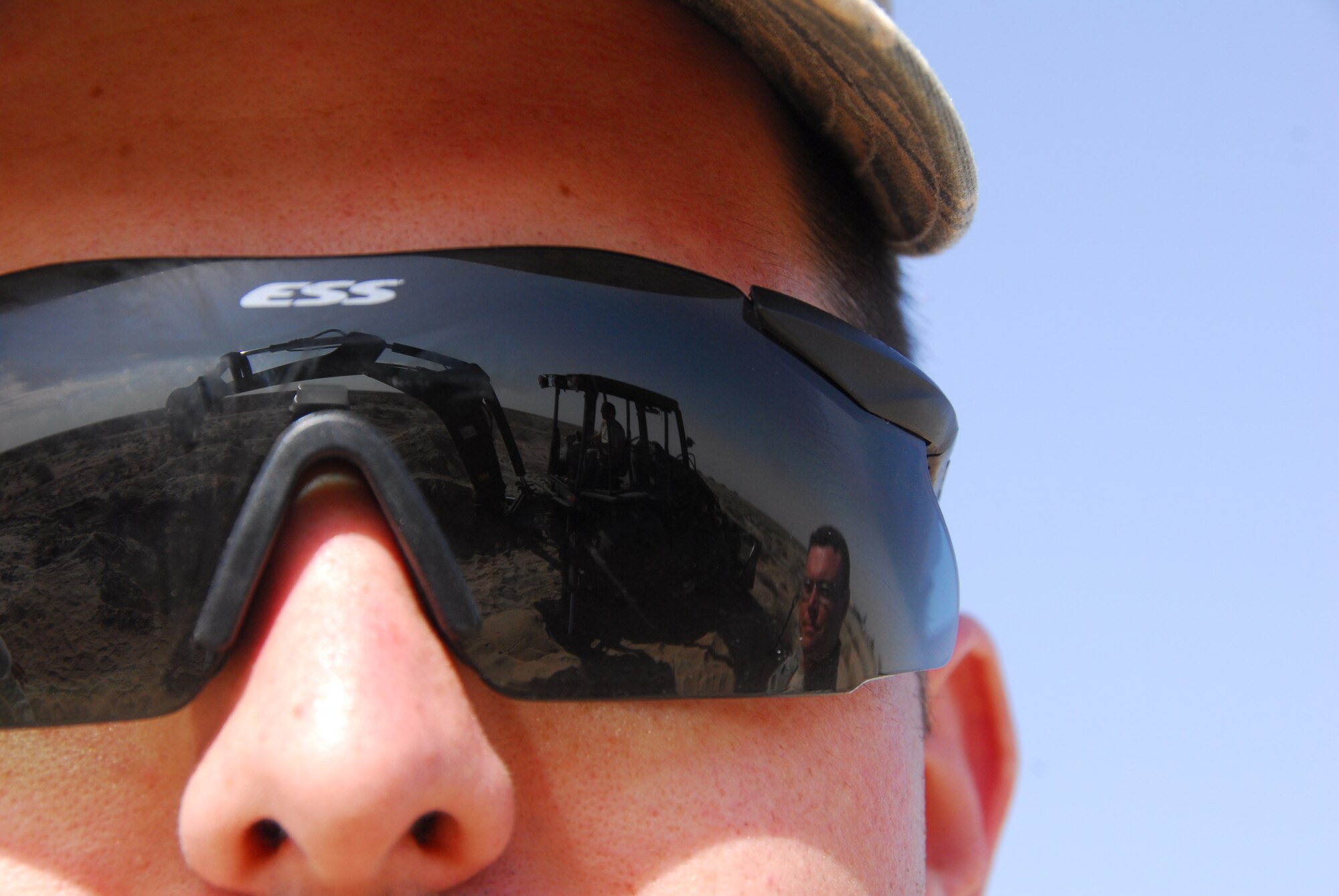 SOUTHWEST ASIA -- Senior Airman Benjamin Hayes, 386th Air Expeditionary Wing broadcaster, looks on with flight safety, as an entomologist digs out a fox hole on the flight line to retrieve puppies that were discovered during a Foreign Object Debris walk at an air base in Southwest Asia, March 3. On this base there are several endangered species or native species and the entomologists are only allowed to remove and relocate them. Airman Hayes is deployed from Dyess AFB, Texas and is originally from Easley, S.C. (U.S. Air Force photo/ Senior Airman Courtney Richardson)
