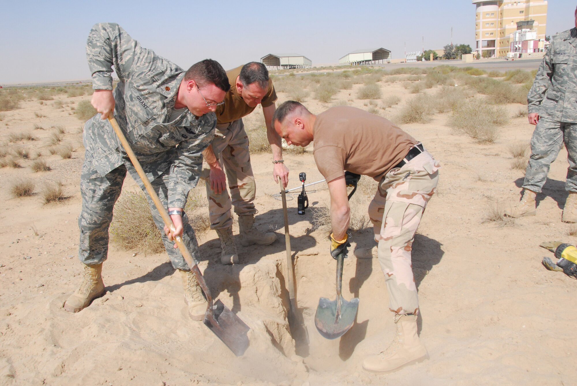 SOUTHWEST ASIA -- Personnel from the 386th Air Expeditionary Wing dig out an existing fox hole on the flight line to pull out puppies at an air base in Southwest Asia, March 3. After the confirmation that the puppies were in the hole, the fire department, flight safety and entomologist responded. (U.S. Air Force photo/ Senior Airman Courtney Richardson)