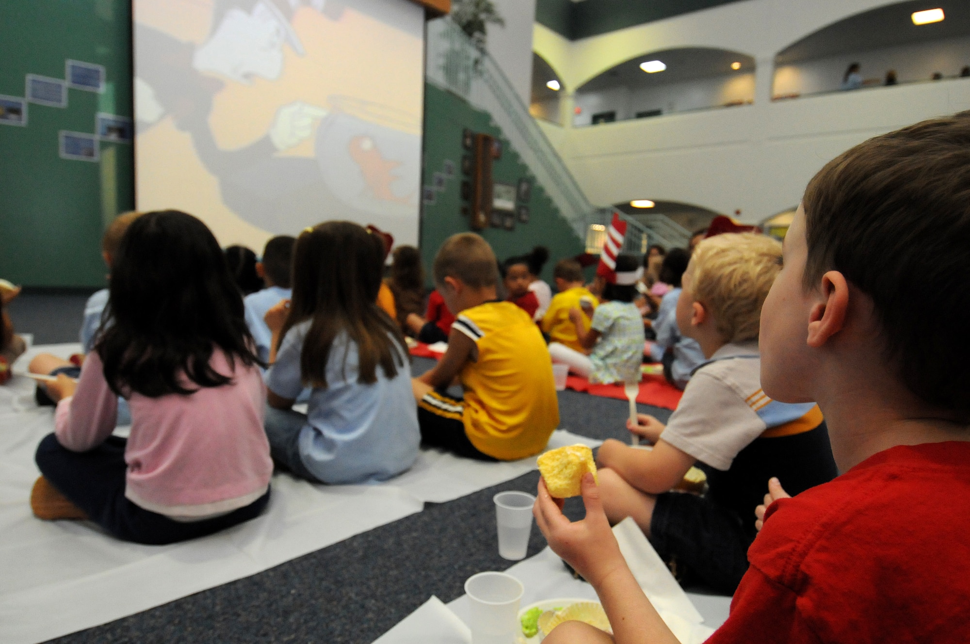 ANDERSEN AIR FORCE BASE, Guam - Andersen Elementary School student's watch Dr. Seuss videos while eating green eggs and ham during the Dr. Seuss Book Camp here March 6. The students read several Dr. Seuss books throughout the week with mixtures of worksheets, puzzles and coloring sheets to familiarize themselves with the creative writer. (U.S. Air Force photo by Airman 1st Class Courtney Witt)
