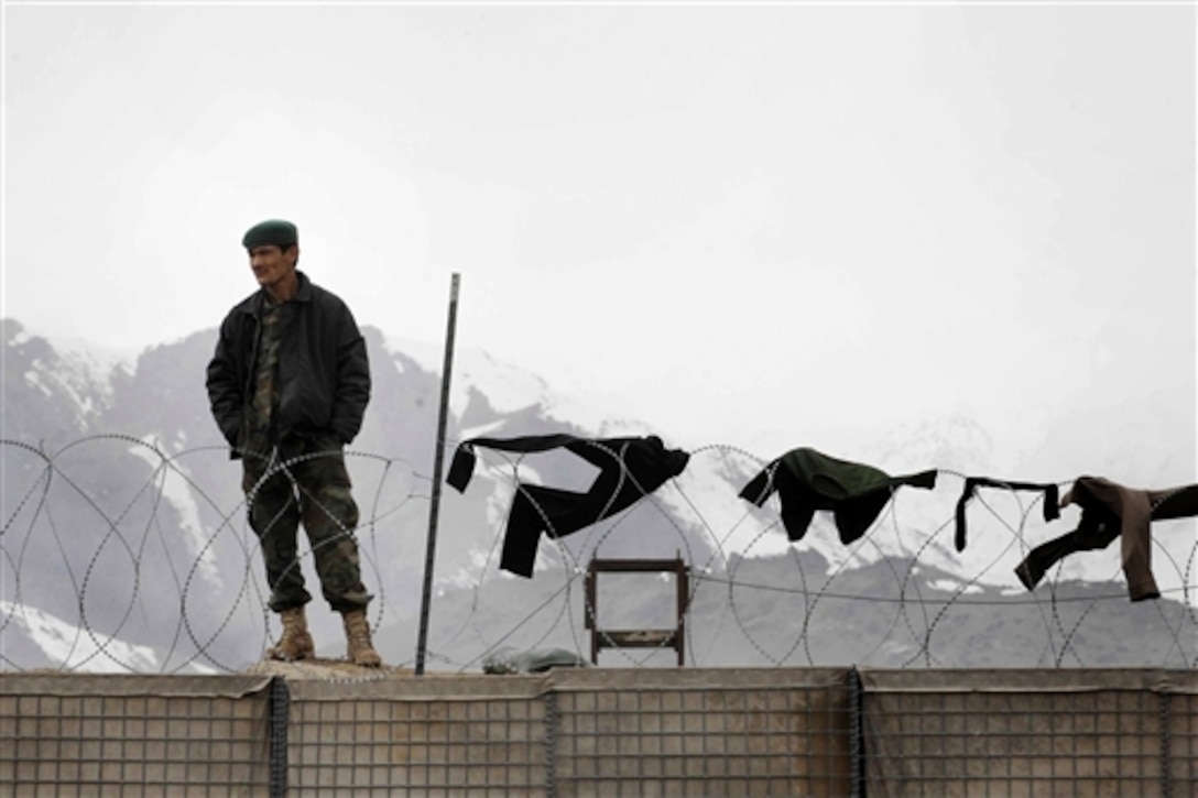 An Afghan National Army soldier stands on a barrier wall on Forward Operating Base Airborne in Wardak province, Afghanistan, March 6, 2009. An Afghan battalion is located on the base with the U.S. Army soldiers from the 10th Mountain Division's 3rd Brigade Combat Team, enabling both forces to conduct joint operations in the province. 