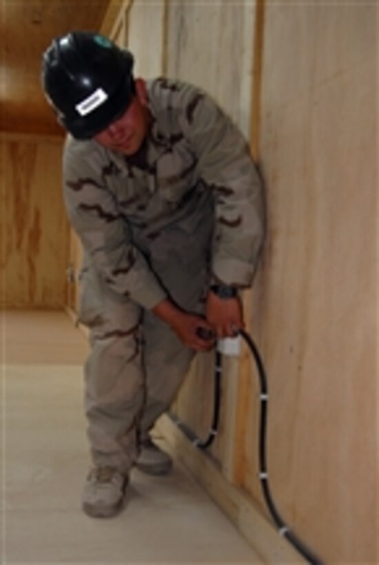 U.S. Navy Petty Officer 3rd Class Joe Nichols from Amphibious Construction Battalion 2 tests the electrical outlets during a completion-of-work tour through the new barracks and dining facility at Patrol Base Mahawil, Iraq, on March 2, 2009.  