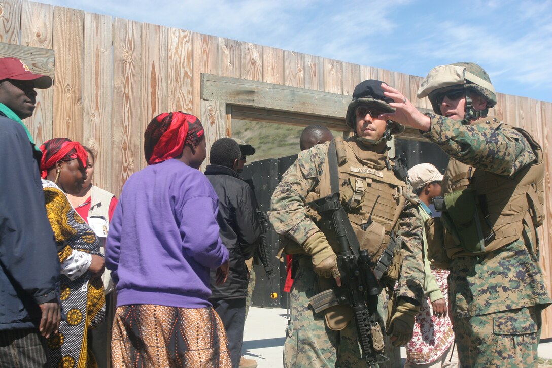 Lieutenant Col. James Hensien discusses the security posture with a Marine from Combat Logistics Battalion 11 during a humanitarian aid and disaster relief exercise here March 5. CLB-11, the combat service support element of the 11th Marine Expeditionary Unit, took part in a 3-day training scenario where they provided food, water and medical care to a village in need. Hensien is the commanding officer of CLB-11.