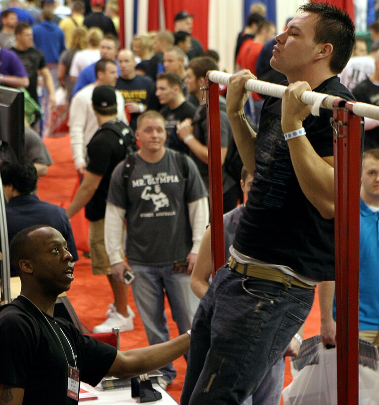 Sgt. Quentin Matthews, a recruiter at Recruiting Sub-Station North Columbus, counts pull-up repetitions during a Marine Corps Pull-up Challenge at the 2009 Arnold Sports Festival March 7. This three-day event is now the world’s largest multi-sport fitness weekend.