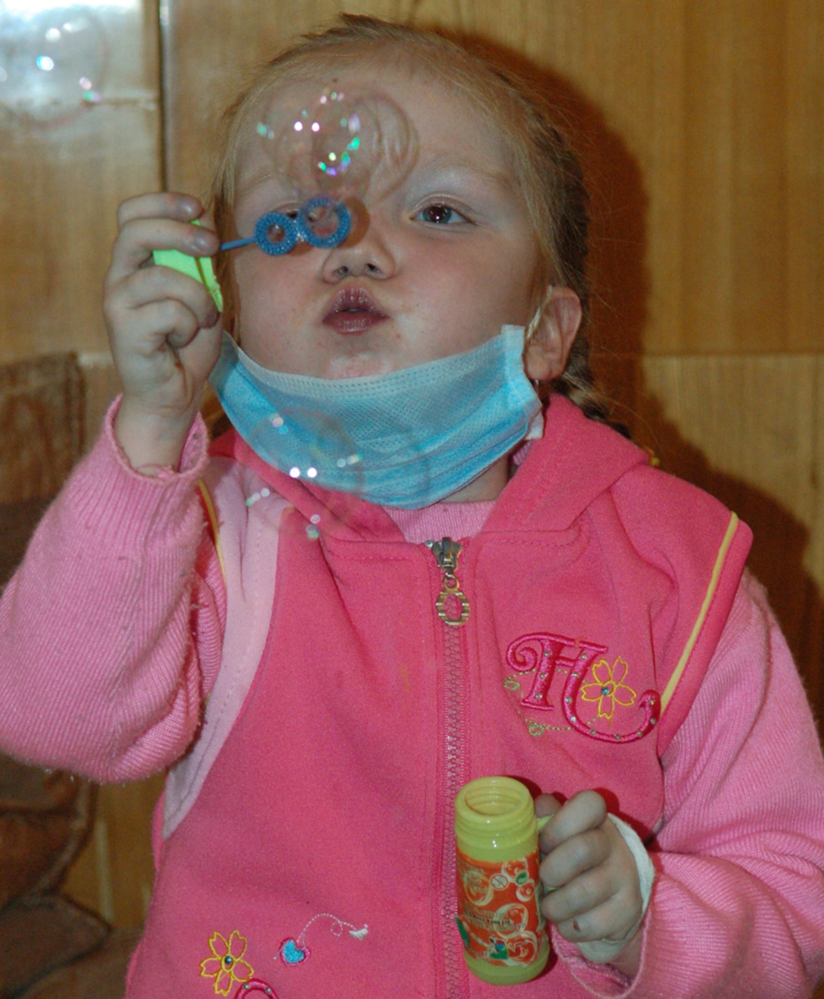 A 5-year-old Kyrgyz girl recovering from heart surgery discovers the joys of bubble blowing for the first time March 4 at the Bishkek Institute of Cardiology, known as the Children's Heart Hospital, in Kyrgyzstan. Airmen with the Manas Air Base Outreach Society spent some of their off-duty time with the young patients in the heart ward. During this visit, MABOS donated approximately $4,500 to the hospital to pay for eight heart surgeries, in addition to 129 others funded by MABOS since 2003. (U.S. Air Force photo/Maj. Damien Pickart)