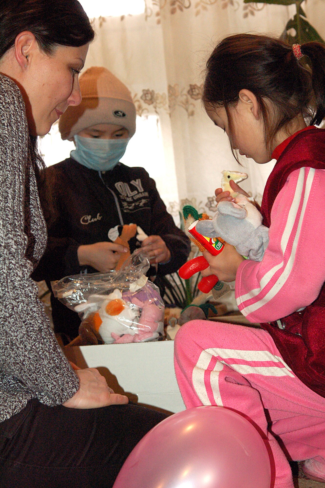 Tech. Sgt. Phyllis Hanson sits with two heart surgery patients as they pick out their favorite stuffed toy March 4 at the Children's Heart Hospital in Bishkek, Kyrgyzstan. During the visit, Sergeant Hanson and several other Manas Air Base Outreach Society volunteers spent off-duty time with children who suffer from congenital heart defects and require life-saving surgeries. They also donated approximately $4,500 to the hospital to fund another eight heart surgeries on top of the 129 MABOS has funded since 2003. Sergeant Hanson is assigned to the 376th Air Expeditionary Wing Public Affairs office and is deployed from Air Education and Training Command Public Affairs at Randolph Air Force Base, Texas. She is originally from Soldier, Iowa. (U.S. Air Force photo/Maj. Damien Pickart)