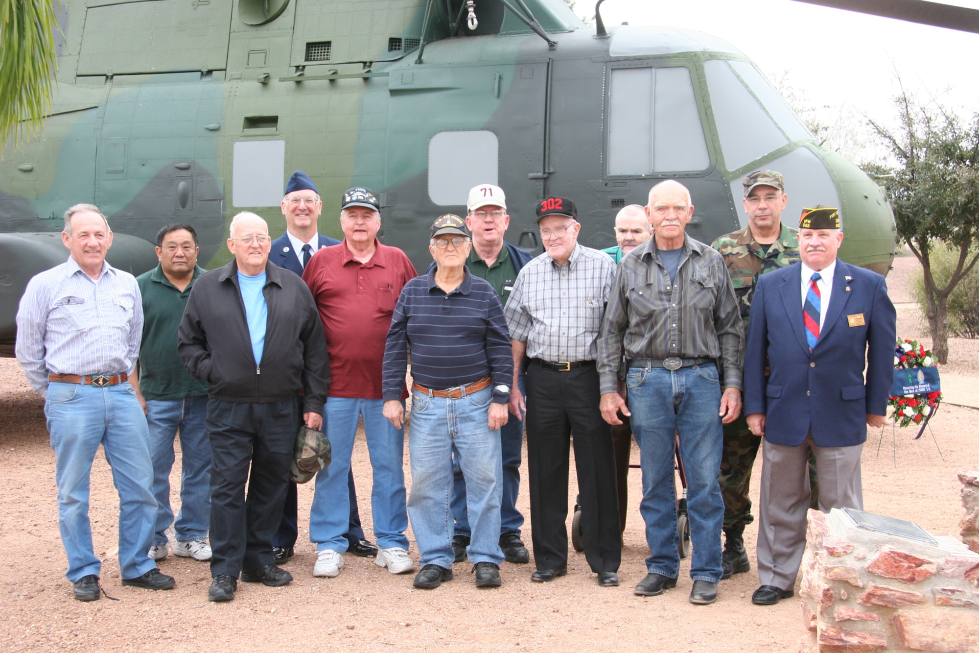 DAVIS-MONTHAN AIR FORCE BASE, Ariz. -- Former members of the 71st Special Operations Squadron and 943rd Rescue Group gather in front of a static display memorial in honor of PONY 1-2 that crashed in a remote desert area 20 miles northwest of the base March 12, 1989. The group was in attendance at a memorial ceremony March 8 to honor the 15 men who died in the crash. U.S. Air Force photo/Master Sgt. Ruby Zarzyczny