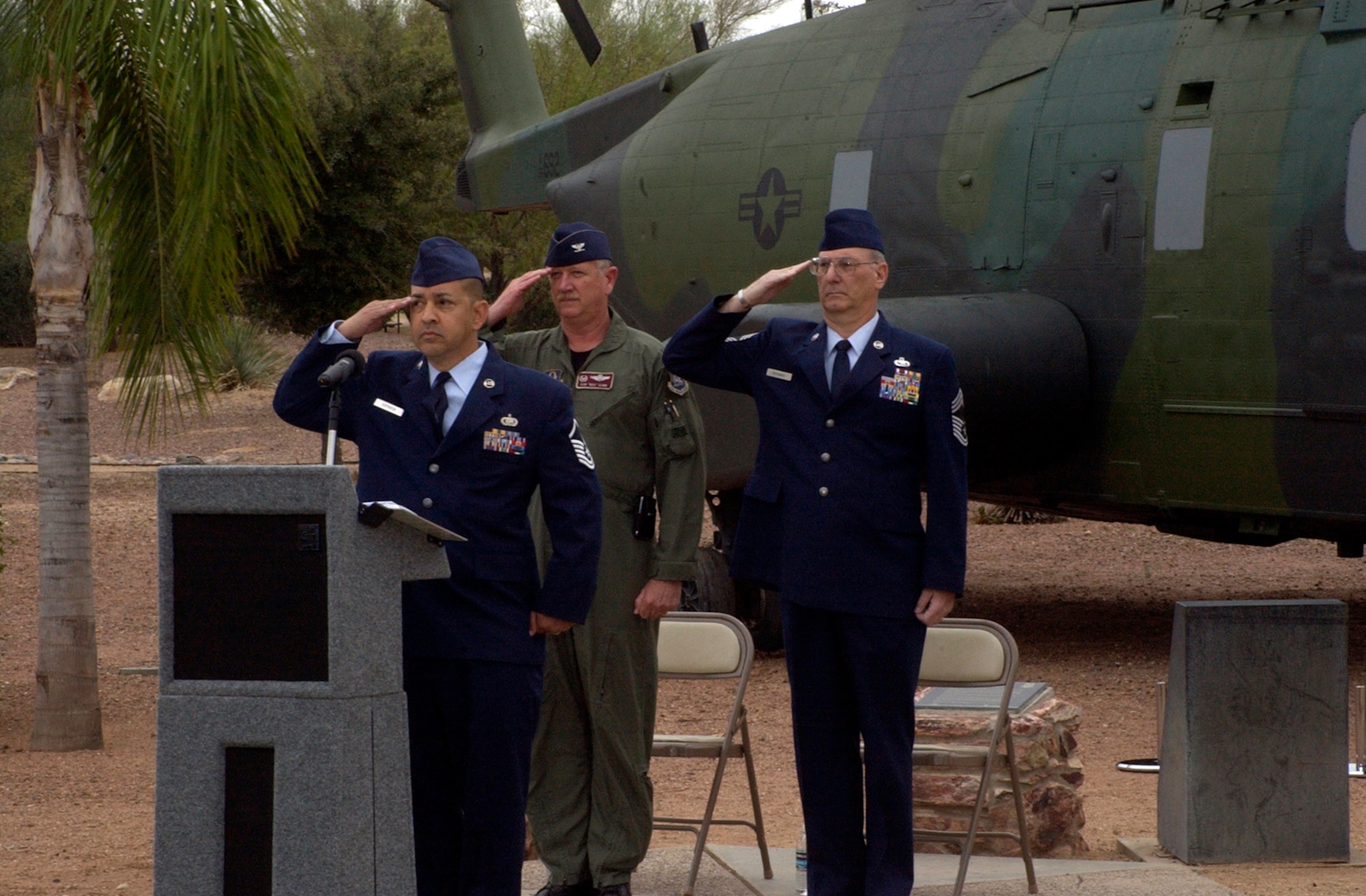 DAVIS-MONTHAN AIR FORCE BASE, Ariz. -- Master Sgt. Dominic Esparaza, of the 943rd Rescue Group Communications Flight, Col. Robert L. Dunn, commander of the 943rd Rescue Group, and retired Chief Master Sgt. Craig Bergman salute the flag during the playing of the National Anthem in front of a static display model of PONY 1-2 during a memorial ceremony held at Heritage Park here March 8. PONY 1-2 crashed during a nighttime training mission March 12, 1989 killing all 15 men on board. U.S. Air Force photo/Master Sgt. Bryan Ripple               