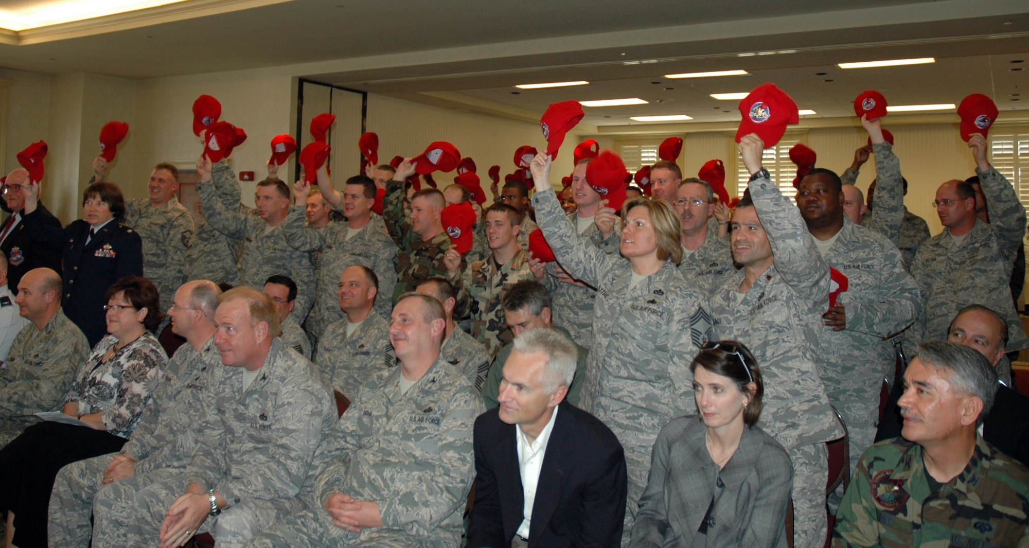 Members of the newly established 560th Red Horse Squadron raise their hats and shout,  "To the horse, to the horse, to the horse!"  The red hats worn by Red Horse members are authorized, signifying the unit's unique mission. (U.S. Air Force photo by/Tech. Sgt. Jeff Kelly)