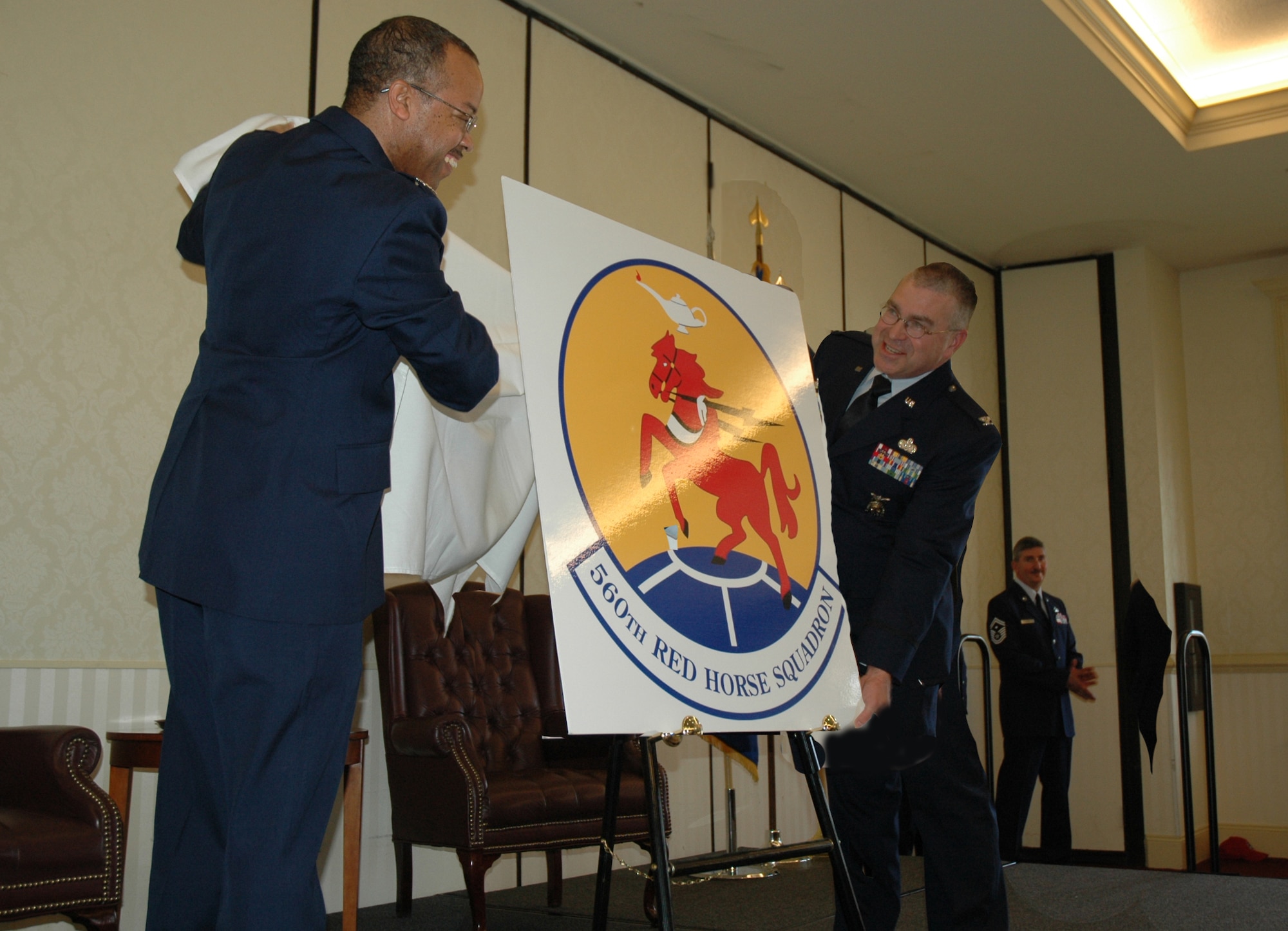 Col. Curtis Williams, 610th Regional Support Group commander at Naval Air Station Joint Reserve Base Fort Worth, Texas, and Col. Danial Leveille, 560th Red Horse Squadron commander, unveil the 560 RHS emblem at a ceremony Sunday. The squadron will consist of 209 personnel and is an engineering unit that provides major force bed-down, damage repair and heavy engineering operations during wartime at locations around the world. (U.S. Air Force graphic by/Tech. Sgt. Jeff Kelly)