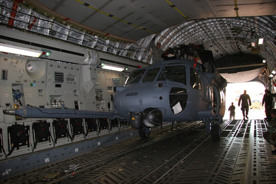 DAVIS-MONTHAN AIR FORCE BASE, Ariz. -- Aircraft maintainters from the 943rd Maintenance Squadron and aircrew members from the 446th Airlift Wing, McChord Air Force Base, Wash., use a powered winch on a 446th AW C-17 to load a HH-60G PAVE HAWK helicopter March 7. Two helicopters were loaded and deployed to Patrick Air Force Base, Fla. to augment launch and recovery of Space Shuttle Discovery. All together, 20 Reservists from the 943rd Rescue Group are supporting this mission. U.S. Air Force photo/Master Sgt. Ruby Zarzyczny