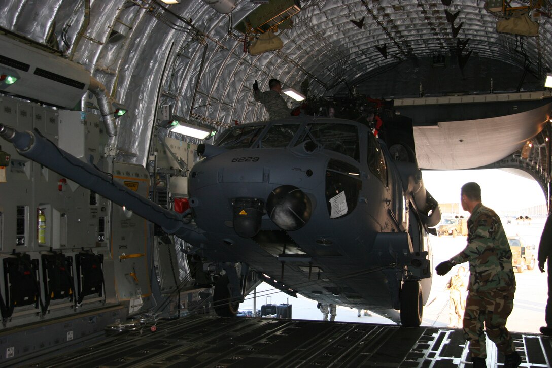 DAVIS-MONTHAN AIR FORCE BASE, Ariz. -- Aircraft maintainters from the 943rd Maintenance Squadron and aircrew members from the 446th Airlift Wing, McChord Air Force Base, Wash., use a powered winch on a 446th AW C-17 to load a HH-60G PAVE HAWK helicopter March 7. Two helicopters were loaded and deployed to Patrick Air Force Base, Fla. to augment launch and recovery of Space Shuttle Discovery. All together, 20 Reservists from the 943rd Rescue Group are supporting this mission. U.S. Air Force photo/Master Sgt. Ruby Zarzyczny