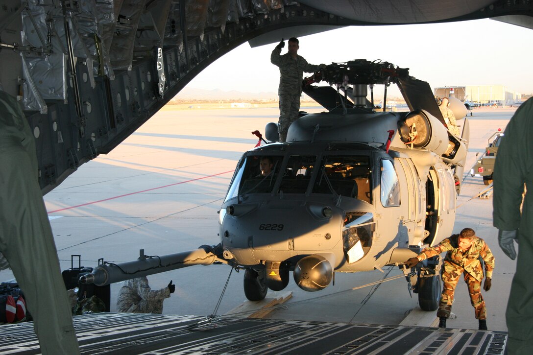 DAVIS-MONTHAN AIR FORCE BASE, Ariz. -- Aircraft maintainters from the 943rd Maintenance Squadron and aircrew members from the 446th Airlift Wing, McChord Air Force Base, Wash., use a powered winch on a 446th AW C-17 to load a HH-60G PAVE HAWK helicopter March 7. Two helicopters were loaded and deployed to Patrick Air Force Base, Fla. to augment launch and recovery of Space Shuttle Discovery. All together, 20 Reservists from the 943rd Rescue Group are supporting this mission. U.S. Air Force photo/Master Sgt. Ruby Zarzyczny