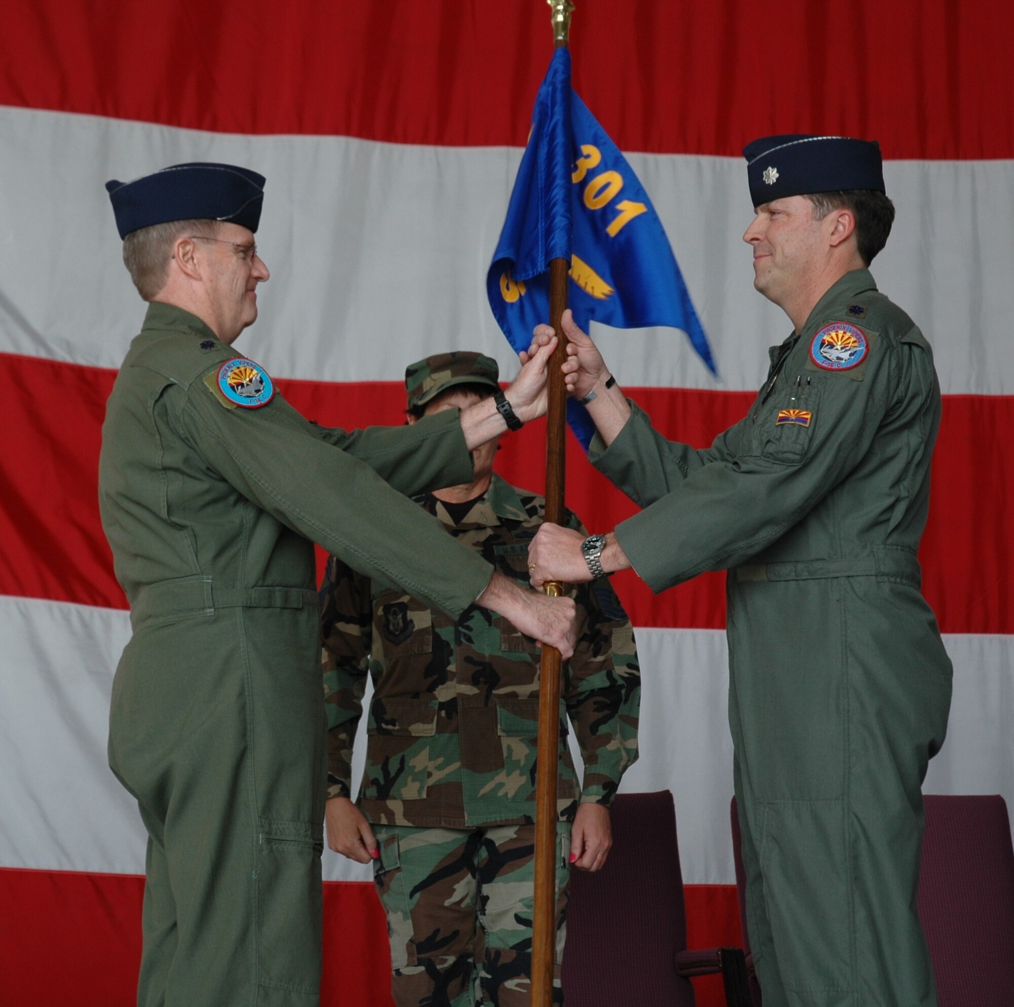 Lt. Col. Dave Davis, 944th Operations Group commander, passes the guidon to Lt. Col. Steve Speckhard March 6 as he assumes command of the 301st Fighter Squadron. Lt. Col. Jay Paulus relinquished command during the change-of-command ceremony. (U.S. Air Force photo/Tech. Sgt. Susan Stout)
