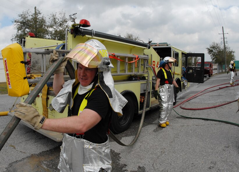 Staff Sgt. Shannon Daniels, a firefighter with the 919th Civil Engineer Squadron, extends the hose away from the fire engine to remove the water after a simulated burning building exercise March 7 at Duke Field.  The exercise, performed as part of the Unit Compliance Inspection, had the firefighters secure the scene, put out the fire, evacuate victims and set up a triage.  The entire scenario lasted less than 15 minutes, with two teams entering the building and evacuating two simulated victims.  U.S. Air Force photo / Staff Sgt. Samuel King Jr.