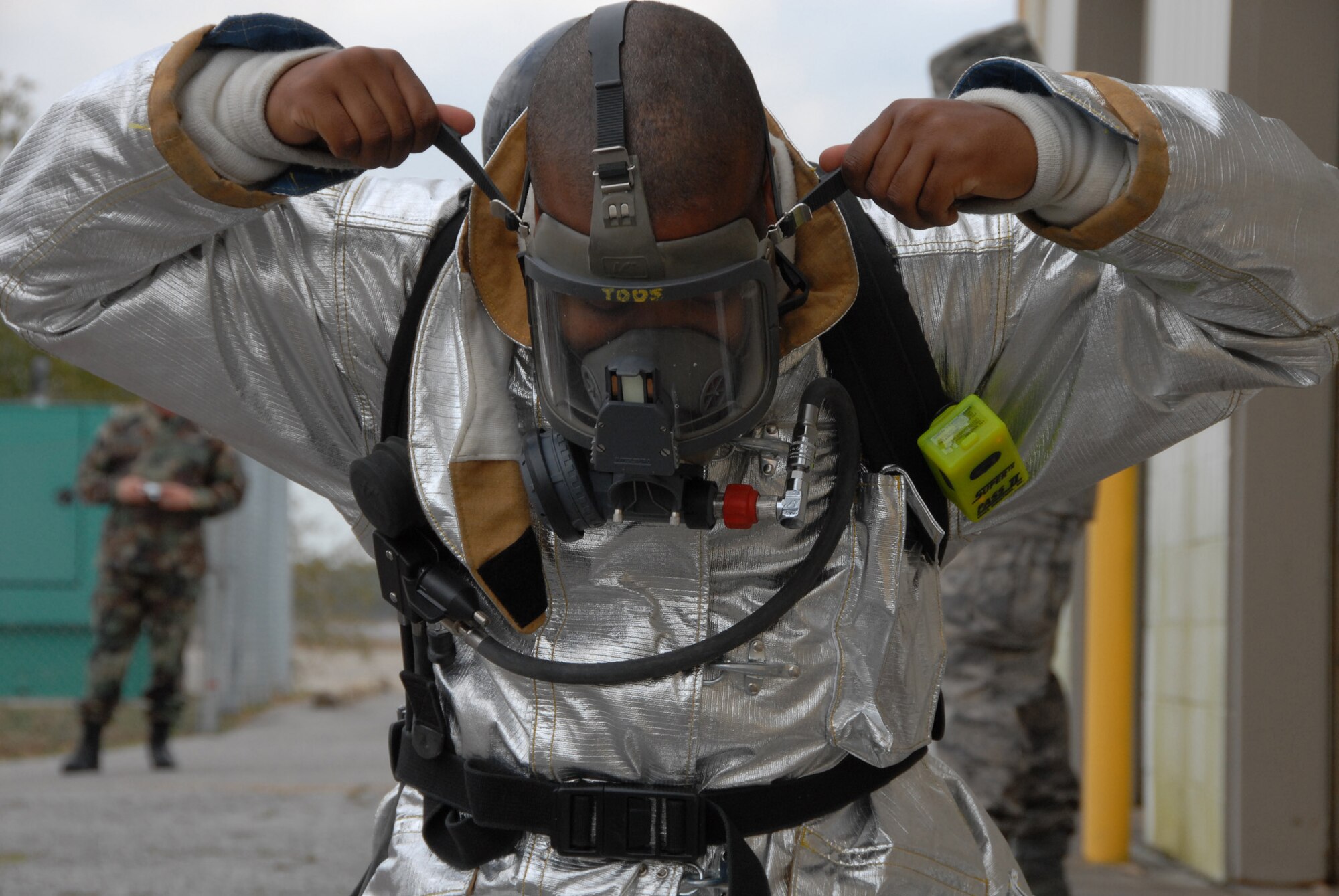 Senior Airman Ronald Haynes, a firefighter with the 919th Civil Engineer Squadron, tightens down his gas mask before entering a simulated burning building during a fire exercise March 7 at Duke Field.  The exercise, performed as part of the Unit Compliance Inspection, had the firefighters secure the scene, put out the fire, evacuate victims and set up a triage.  The entire scenario lasted less than 15 minutes, with two teams entering the building and evacuating two simulated victims.  U.S. Air Force photo / Staff Sgt. Samuel King Jr.