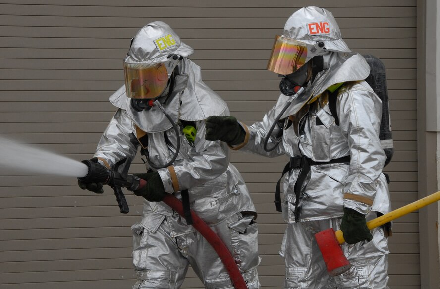 A firefighter checks the hose to ensure it is full of water before entering a simulated burning building during a fire exercise March 7 at Duke Field.  The exercise, performed as part of the Unit Compliance Inspection, had the firefighters secure the scene, put out the fire, evacuate victims and set up a triage.  The entire scenario lasted less than 15 minutes, with two teams entering the building and evacuating two simulated victims.  U.S. Air Force photo / Staff Sgt. Samuel King Jr.