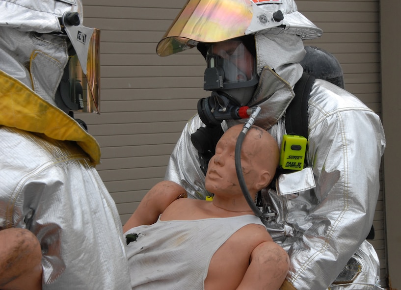 Senior Airman Brandon Sherouse and Staff Sgt. Ronald McCoy carry out a victim from a simulated burning building during a fire exercise March 7 at Duke Field.  The exercise, performed as part of the Unit Compliance Inspection, had the firefighters secure the scene, put out the fire, evacuate victims and set up a triage.  The entire scenario lasted less than 15 minutes, with two teams entering the building and evacuating two simulated victims.  U.S. Air Force photo / Staff Sgt. Samuel King Jr.