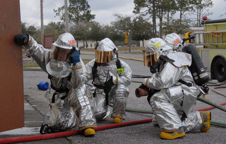 Firefighters with the 919th Civil Engineer Squadron wait to see another team is needed to enter the building during a simulated burning building exercise March 7 at Duke Field.  The exercise, performed as part of the Unit Compliance Inspection, had the firefighters secure the scene, put out the fire, evacuate victims and set up a triage.  The entire scenario lasted less than 15 minutes, with two teams entering the building and evacuating two simulated victims.  U.S. Air Force photo / Staff Sgt. Samuel King Jr.