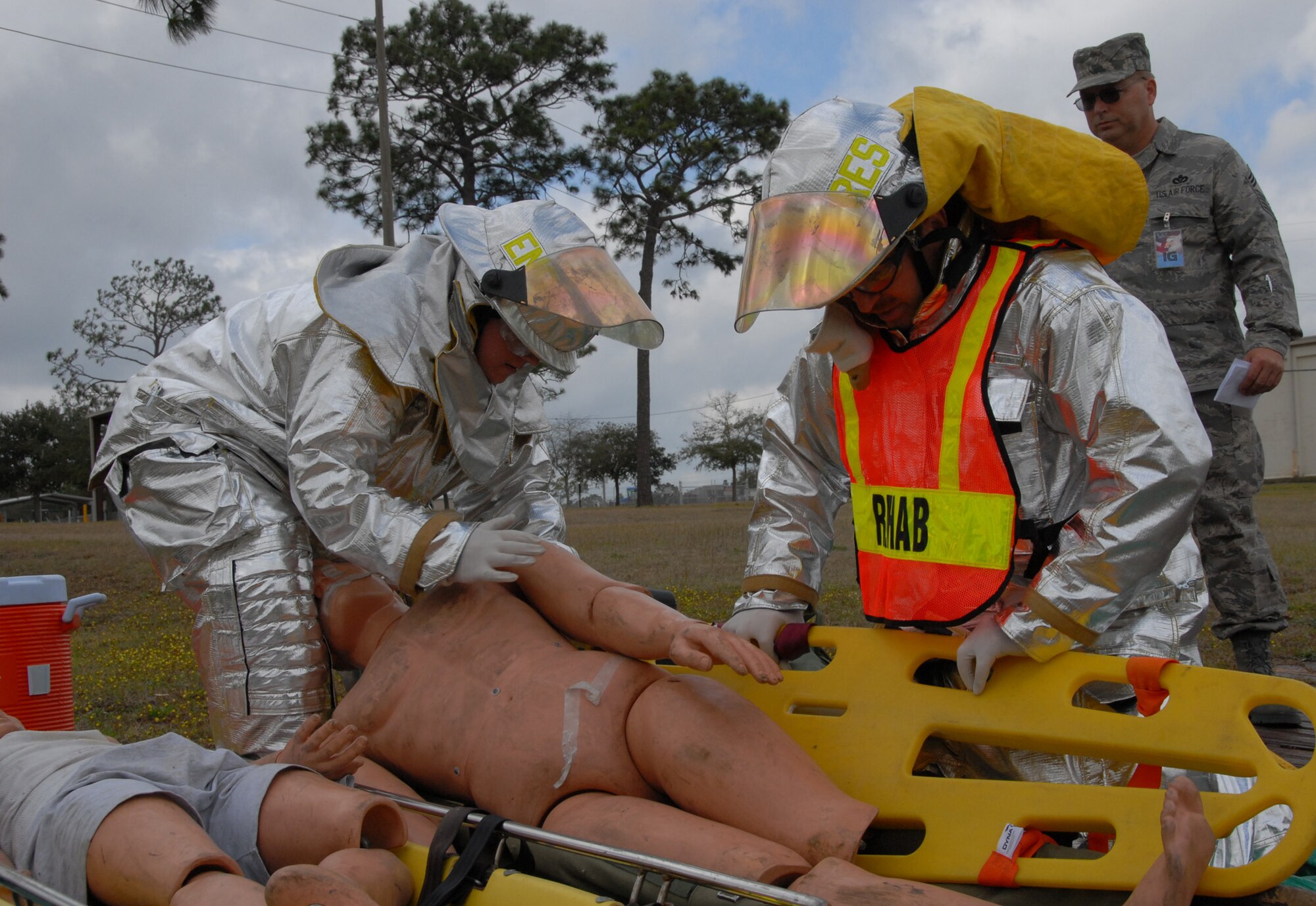 Senior Airman Timothy Henderson and Staff Sgt. David Jacobs, firefighters with the 919th Civil Engineer Squadron, transfer a victim to a gurney at the simulated triage area after evacuating him from the building during a fire exercise March 7 at Duke Field.  The exercise, performed as part of the Unit Compliance Inspection, had the firefighters secure the scene, put out the fire, evacuate victims and set up a triage.  The entire scenario lasted less than 15 minutes, with two teams entering the building and evacuating two simulated victims.  U.S. Air Force photo / Staff Sgt. Samuel King Jr.