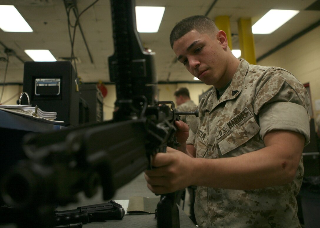 Cpl. Miguel A. Garcia, small arms repair clerk, 2nd Mainteance Battalion, 2nd Marine Logistics Group, works on a weapon in his shop.  The Guaynabo, Puerto Rico native was one of two Marines chosen to help teach the Ghanian Army armory procedures and weapons maintenance.
