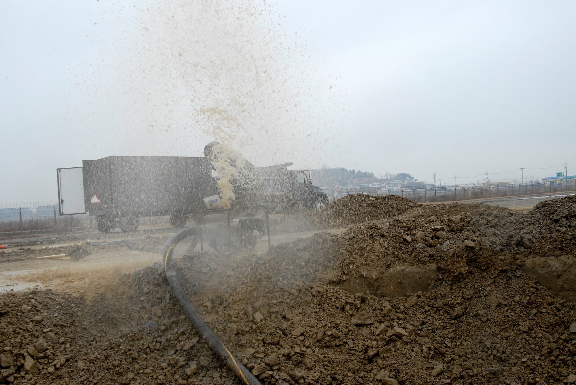 Water sprays into the air as Airmen from the 8th Civil Engineer Squadron drain a crater during an Airfield Damage Repair exercise at Kunsan Air Base, Republic of Korea, March 5, 2009. ADR is a temporary fix on damage caused to the airfield by enemy fire to allow aircraft to quickly get back in the air. (U.S. Air Force Photo by SSgt Jason Colbert)