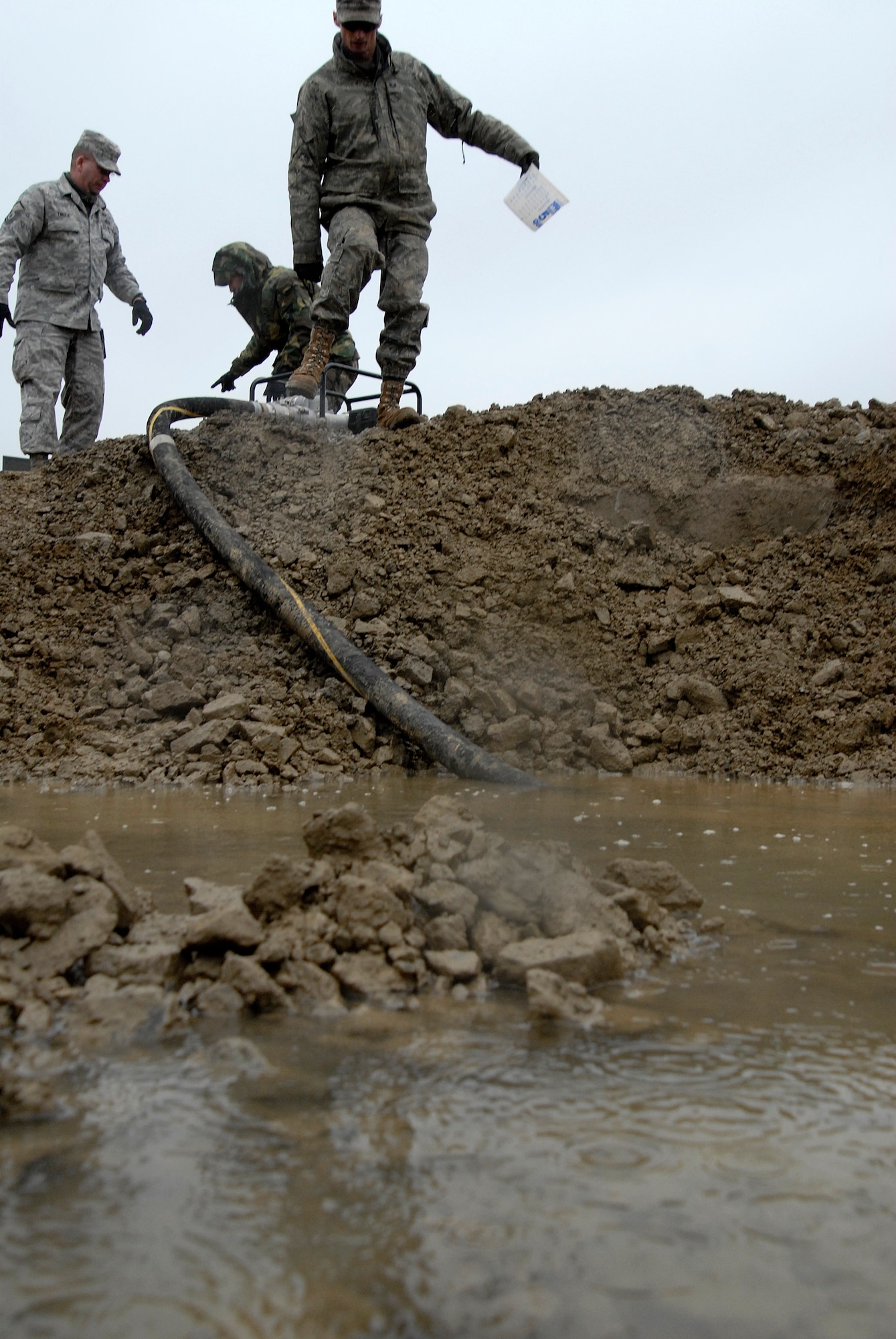 Airmen from the 8th Civil Engineer Squadron pump water from a crater during an Airfield Damage Repair exercise at Kunsan Air Base, Republic of Korea, March 5, 2009. ADR is a temporary fix on damage caused to the airfield by enemy fire to allow aircraft to quickly get back in the air. (U.S. Air Force Photo by SSgt Jason Colbert)
