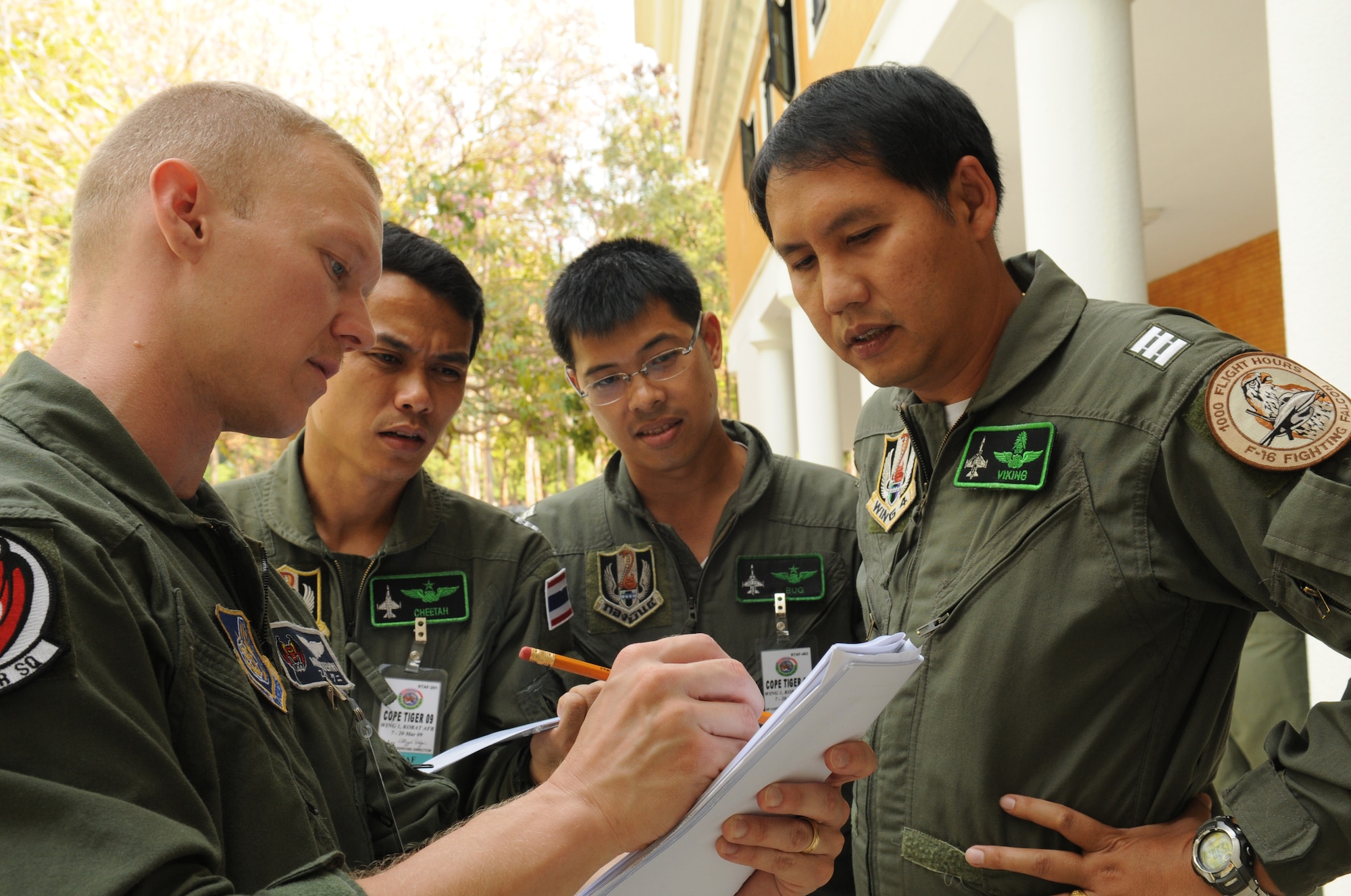 Capt. Mike Kuehni, deployed to Cope Tiger 2009 from the 44th Fighter Squadron at Kadena Air Base, Japan, discusses flight operations with Royal Thai Air Force Squadron Leader S. Sak, Wing Commander N.Don, and Wing Commander Nm. Rat on March 9 at Korat Royal Thai Air Force Base.  Cope Tiger is an annual, multilateral large force aerial exercise conducted in Thailand including U.S., Thai and Singaporean military forces.  The two-week exercise includes both flying and humanitarian missions conducted in Korat and Udon Thani, Thailand.  Cope Tiger 2009 kicked off March 9 and will conclude March 20. (U.S. Air Force Photo/Staff Sgt. Angelique Perez) 