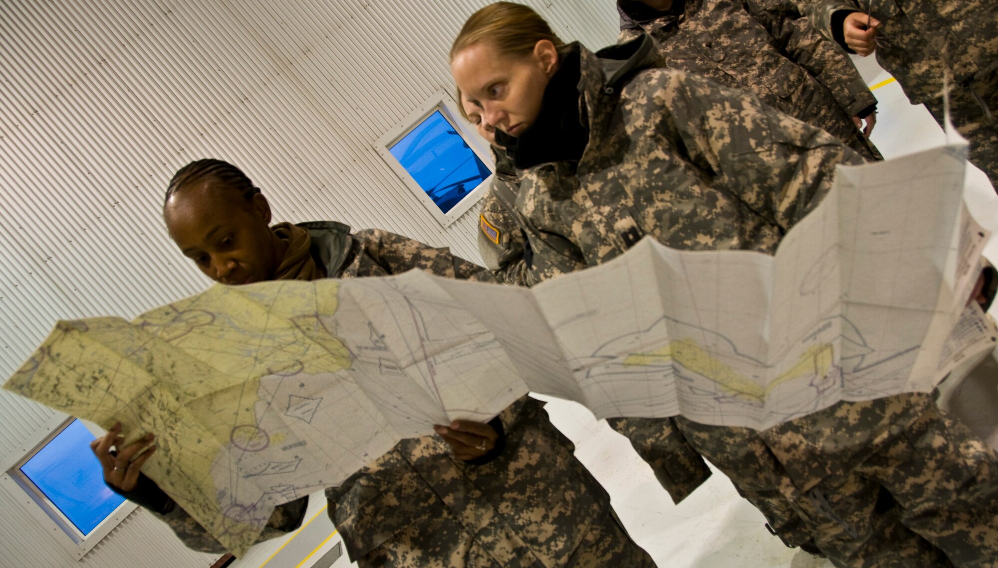 Sgt. Shirley Grant, left, of Beaufort, S.C., and Capt. Amy Clark of Anchorage, Alaska, both from the Army's Southern California District Veterinary Command, locate the village of Alakanuk on a map March 7, 2009. Operation Arctic Care is a joint military medical readiness exercise that brings no-cost health care to underserved Alaskan residents, including dental, optometry and veterinary support. This year's Navy-led mission has teams in 11 villages in Western Alaska's Yukon-Kuskokwim Delta region.(U.S. Air Force photo by Senior Airman Christopher Griffin)