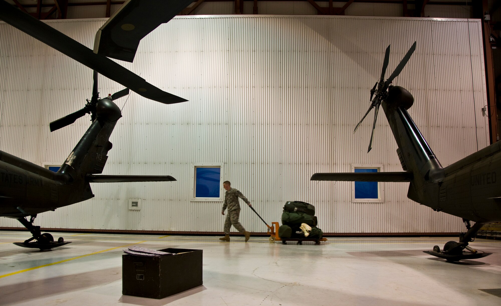 Pfc. Kyle Stangl of Eagle River, Alaska, 1st 207 Aviation Regiment, pulls a dolly of equipment to load on an Black Hawk helicopter that will deliver an Army Veterinary Corps team to Alakanuk, Alaska, on March 7, 2009. Operation Arctic Care is a joint military medical readiness exercise that brings no-cost health care to underserved Alaskan residents, including dental, optometry and veterinary support. This year's Navy-led mission has teams in 11 villages in Western Alaska's Yukon-Kuskokwim Delta region.(U.S. Air Force photo by Senior Airman Christopher Griffin)