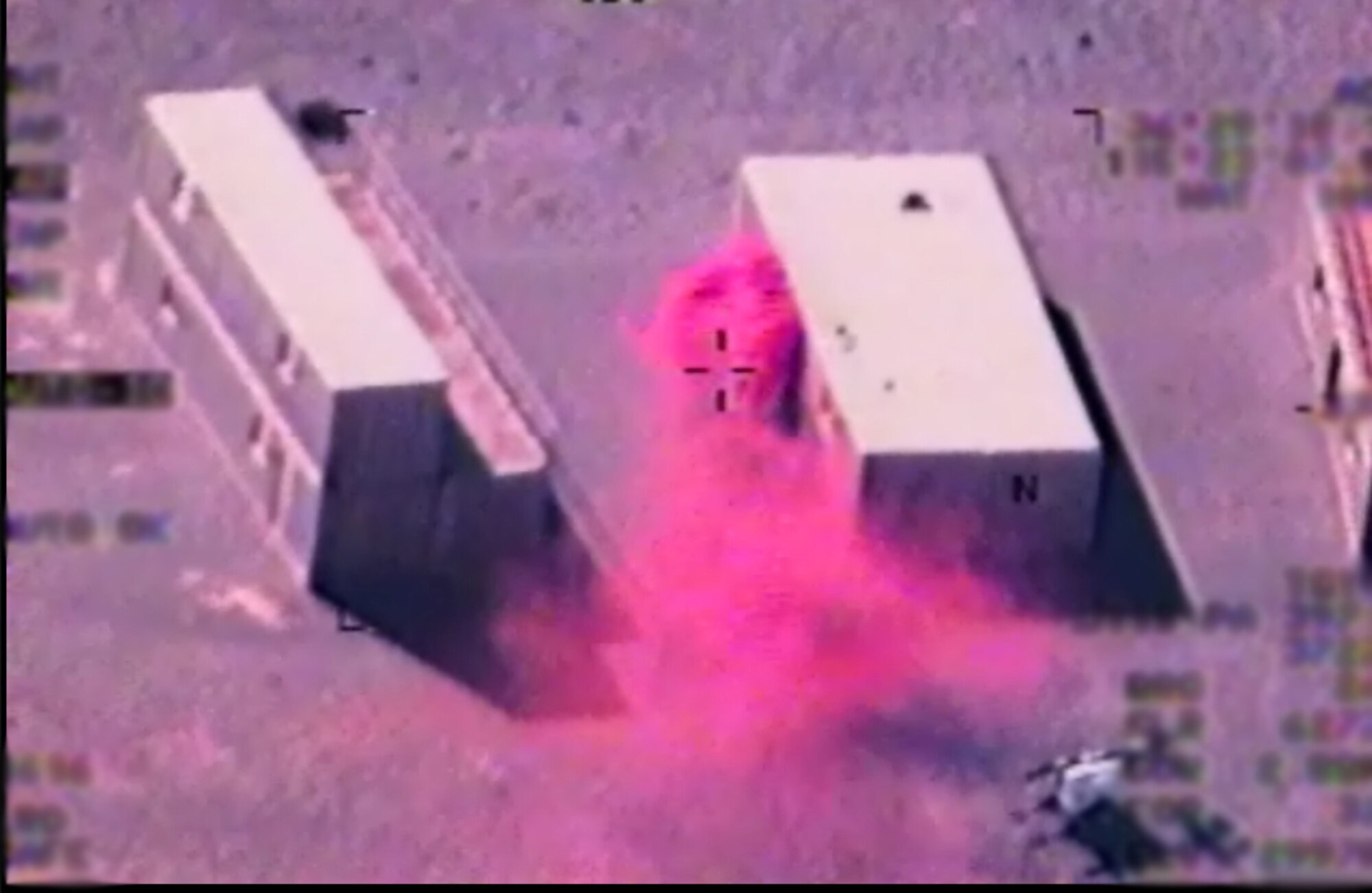 CREECH AFB, Nev. -- As seen from an MQ-1B Predator,  Close Air Support Subject Matter Experts for the 11th Reconnaissance Squadron coordinate via radio with a Predator student for a simulated Hellfire strike on a building while smoke is used to simulate missile impact on a building. One important aspect of Predator Initial Qualification Training is students receiving live Joint Terminal Attack Controller training. In order to enhance their training capabilities, Air Combat Command recently hired contracted Close Air Support Subject Matter Experts. (Courtesy photo)  